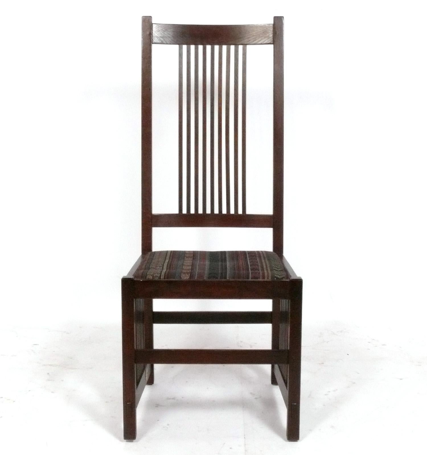 Set of Eight Stickley Mission Oak Arts and Crafts Dining Chairs, American, circa 2000s, including two arm chairs and six side chairs. Originally designed in the 1910s by Gustav Stickley, these are part of the authorized line produced by Stickley in