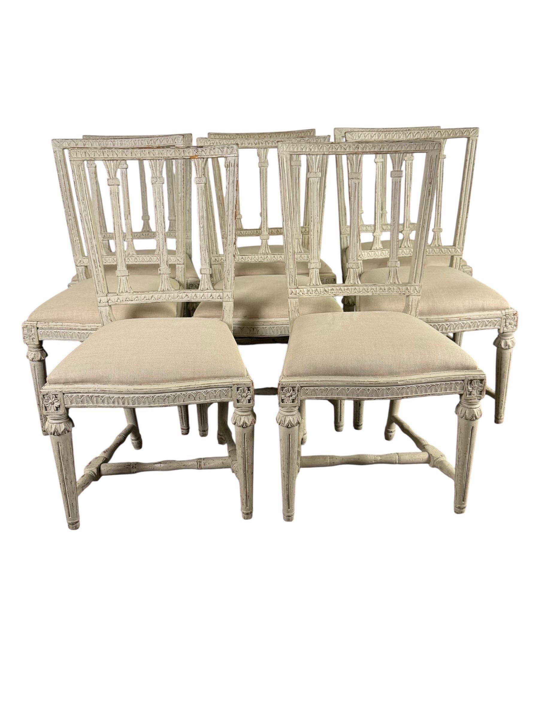 Elegant set of eight Swedish dining chairs in the Gustavian style, late 19th century. The chairs are finely carved with neoclassical detailing, including fluted legs with rosette accents, leaf-carved borders, and square backs with open splat design.