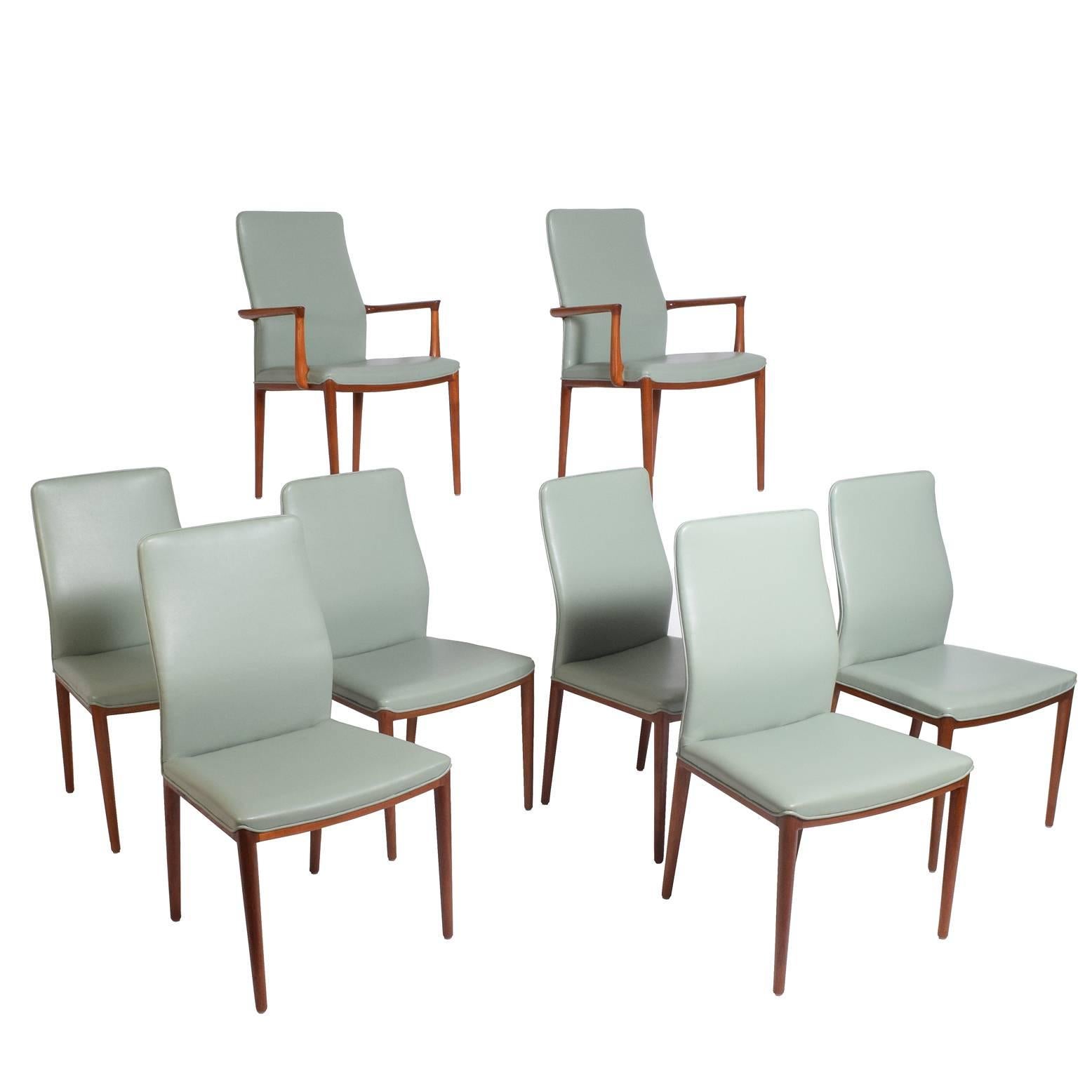 Two armed and six side dining chairs made of solid teak and leatherette upholstery. Designed for formal dining with wonderful back support.
