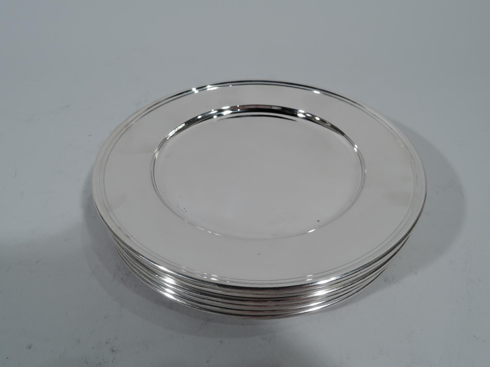 Set of eight modern sterling silver bread and butter plates. Made by Tiffany & Co. in New York. Each: circular well and molded rim. Spare and functional. Hallmark includes pattern no. 20064 (first produced in 1922), order no. 6101, and director’s