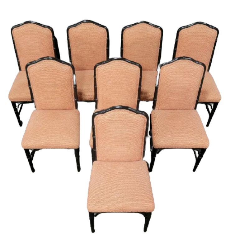 A set of eight armless dining chairs with faux bamboo black frames, arched back and upholstered seats and back