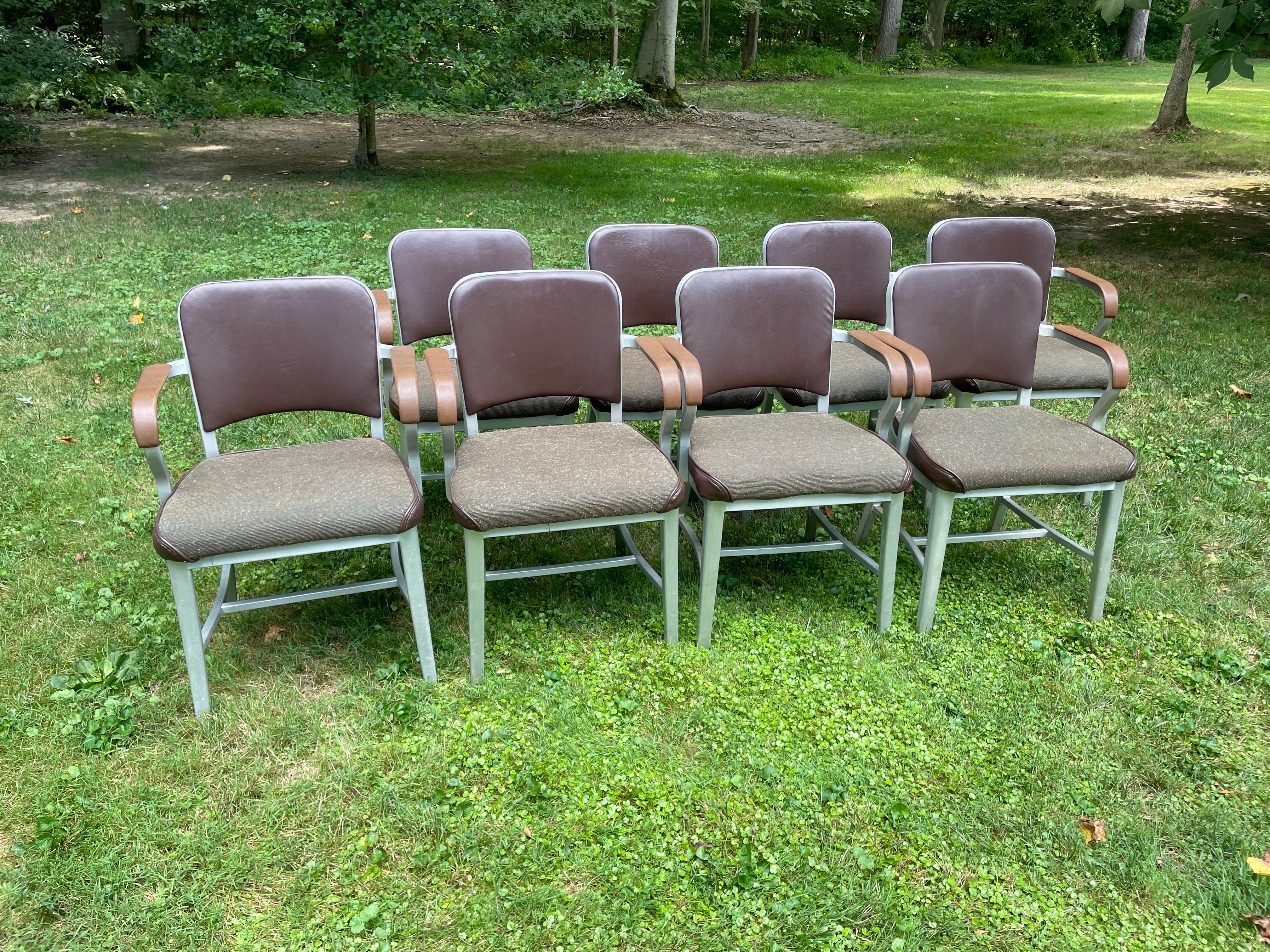 FANTASTIC set of eight vintage Emeco aluminum chairs. Upholstered seats and backs, plastic arm caps. Emeco mark (see photo). Salvaged from a university, these chairs have previously been reupholstered and could go right into service as-is or easily