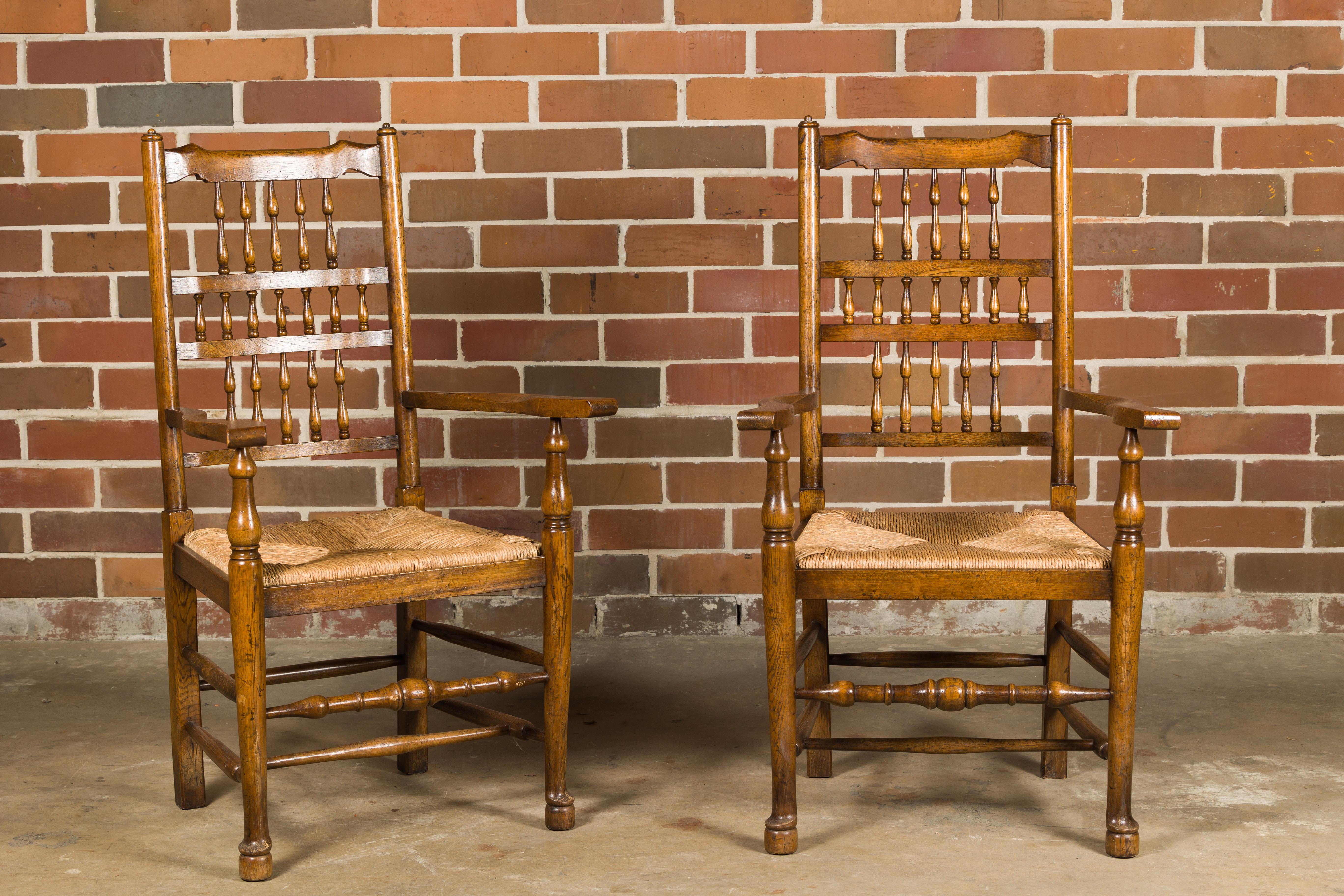 A set of eight French vintage oak dining room chairs with rush seats, comprising of two arms and six sides. This set of eight French vintage oak dining room chairs exudes rustic charm and timeless elegance. 

Each chair features a spindle-shaped