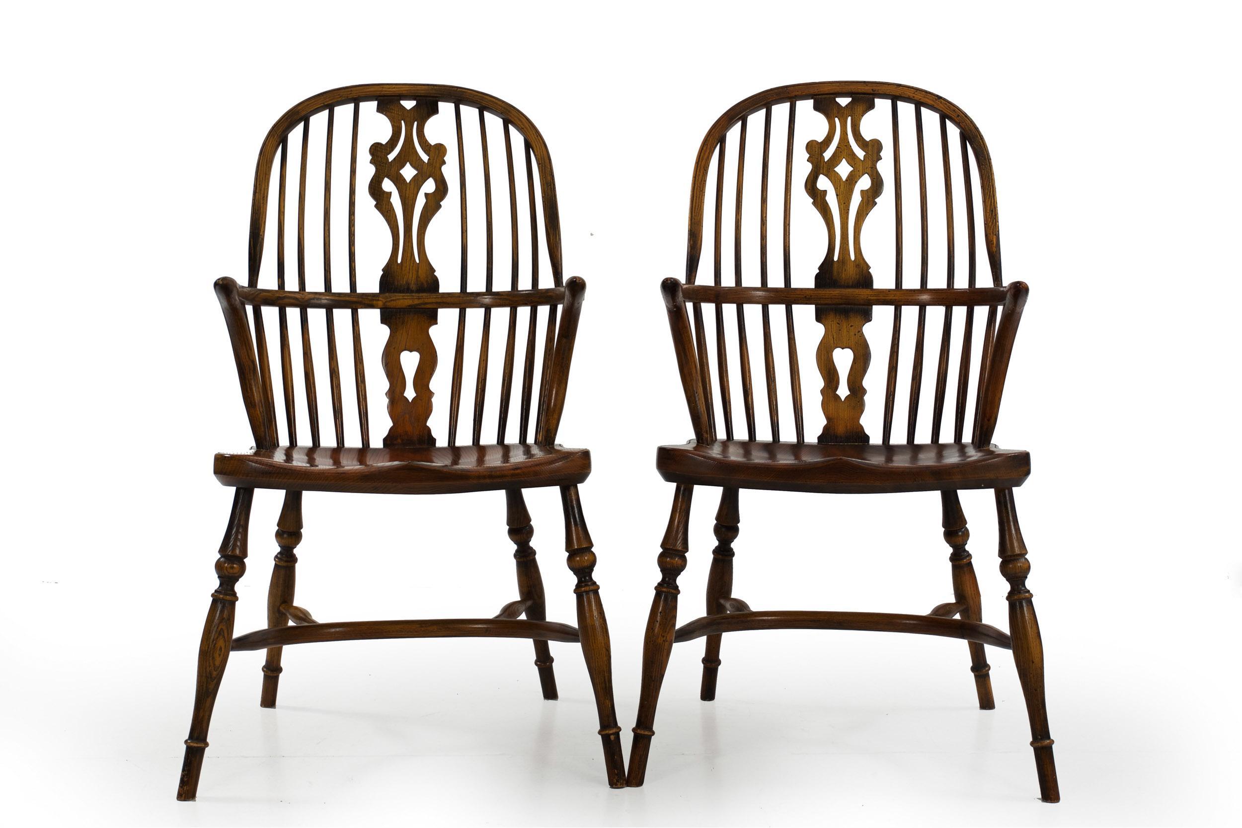 A beautifully benchmade set of eight Windsor-style dining chairs in the English taste, they are crafted with a careful eye to period details throughout. They are all designed as arm chairs with steam-bent hoop rail over eight tapered and swollen