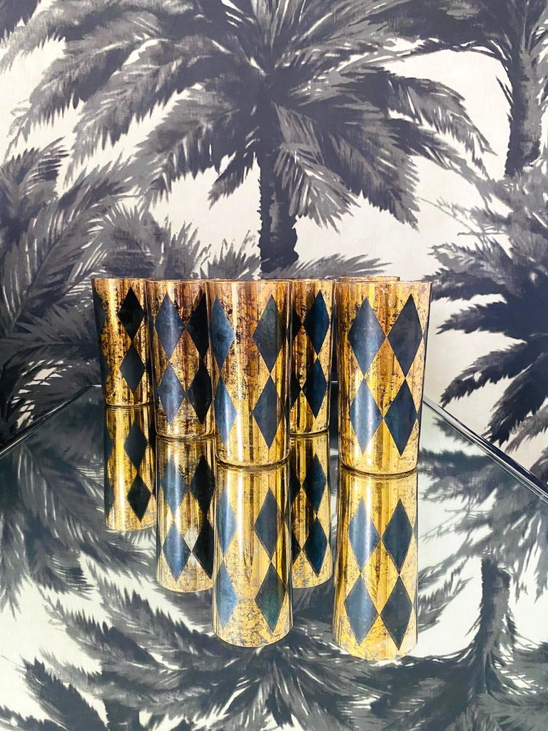 Mid-Century Modern highball or Tom Collins glasses with Harlequin design. Cocktail set includes eight handblown glasses with tapered forms featuring black diamond patterns over clear glass with 22-karat gold leaf flecks throughout. Hollywood Regency
