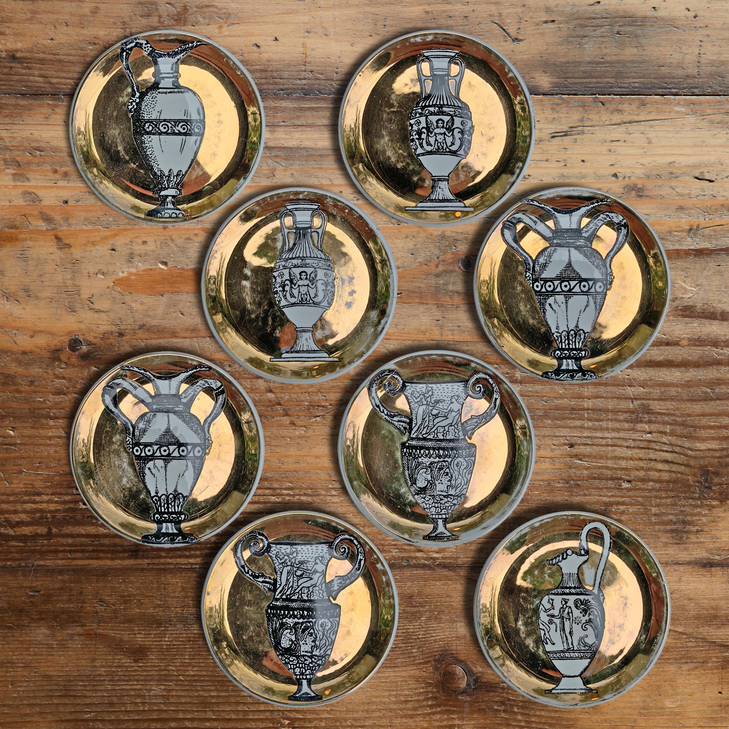 A fabulous set of eight vintage Italian Fornasetti-style gilt painted porcelain coasters, each with a classical Roman urn or vase. Marked 'Bucciarelli, Milano' on the back.