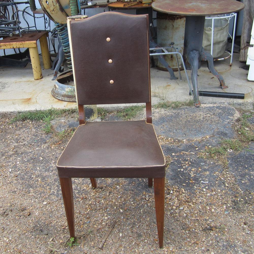 A set of eight vintage Italian high back dining chairs. These chairs feature leather upholstery for the seats and backrests and mahogany legs and frame. In addition, they feature three vertically aligned tufted buttons along the