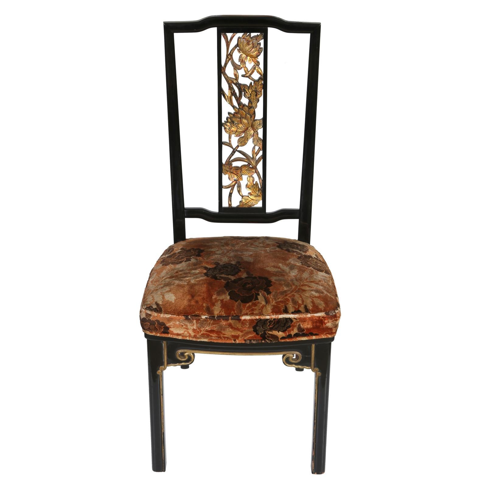A set of eight vintage dining chairs in James Mont style, high gloss black lacquer with gilt detail. The chairs have an open back with gilt floral motif down the center frame and velvet upholstered seats in apricot and gold floral design.