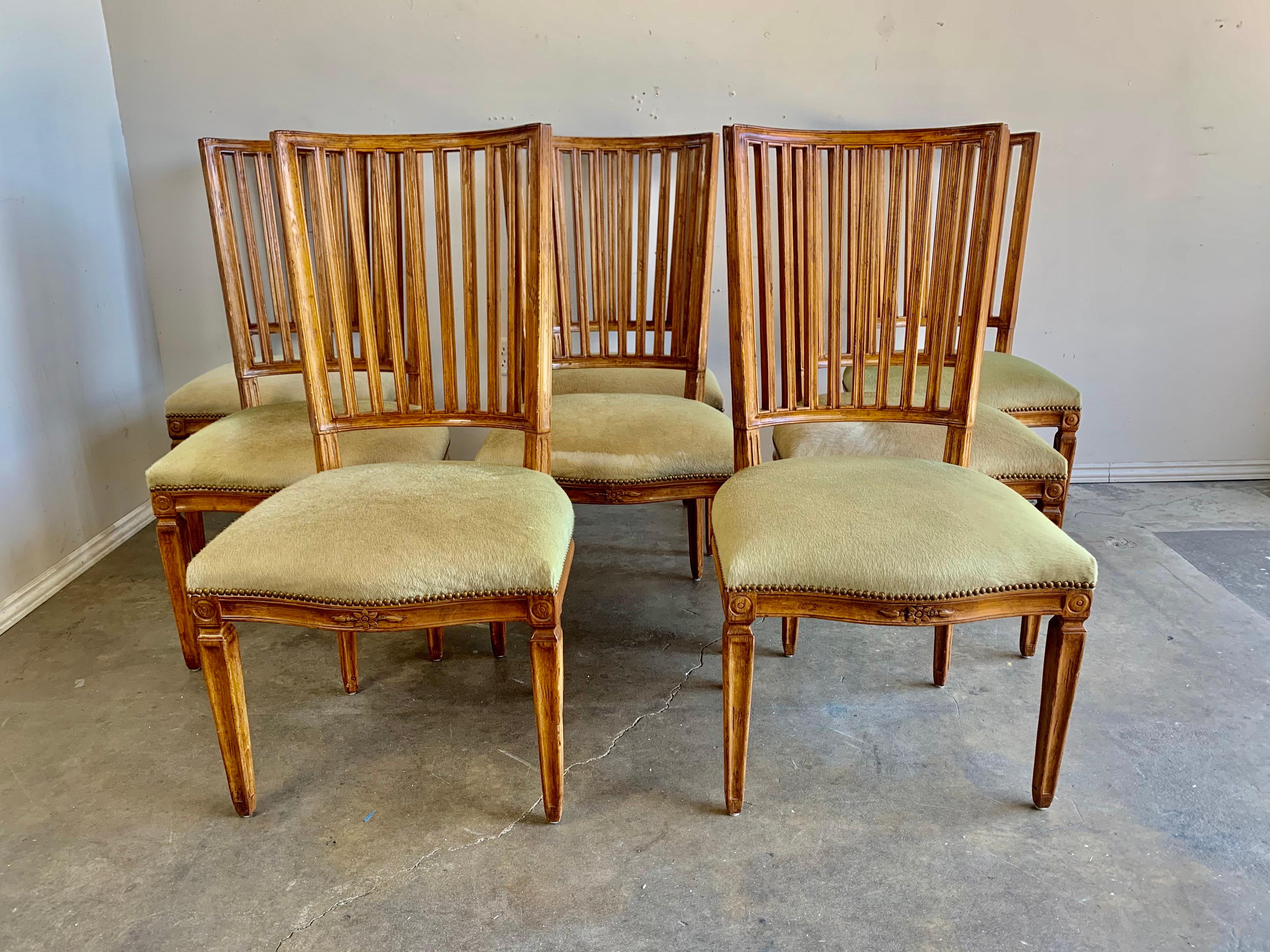 Set of (8) French Louis XVI style armchairs designed and manufactured by Rose Tarlow. The chairs stand on four straight tapered legs. The beautiful spindle style backs and legs are painted in a warm fruitwood coloration. The chairs are upholstered