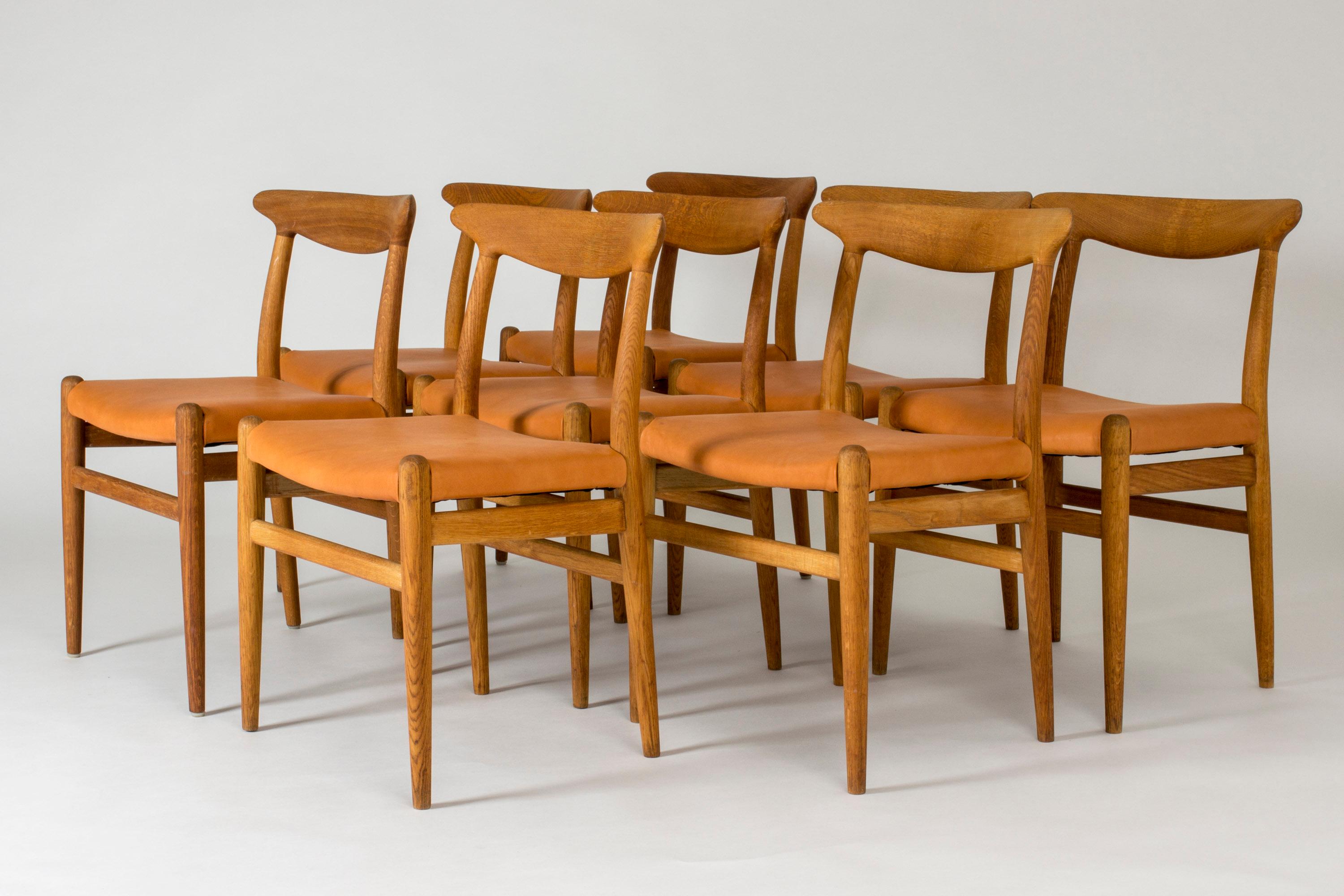 Set of eight beautiful “W2” dining chairs by Hans J. Wegner, made from oak with leather seats. Great woodgrain that follows the lines of the seamlessly sculpted backrests.