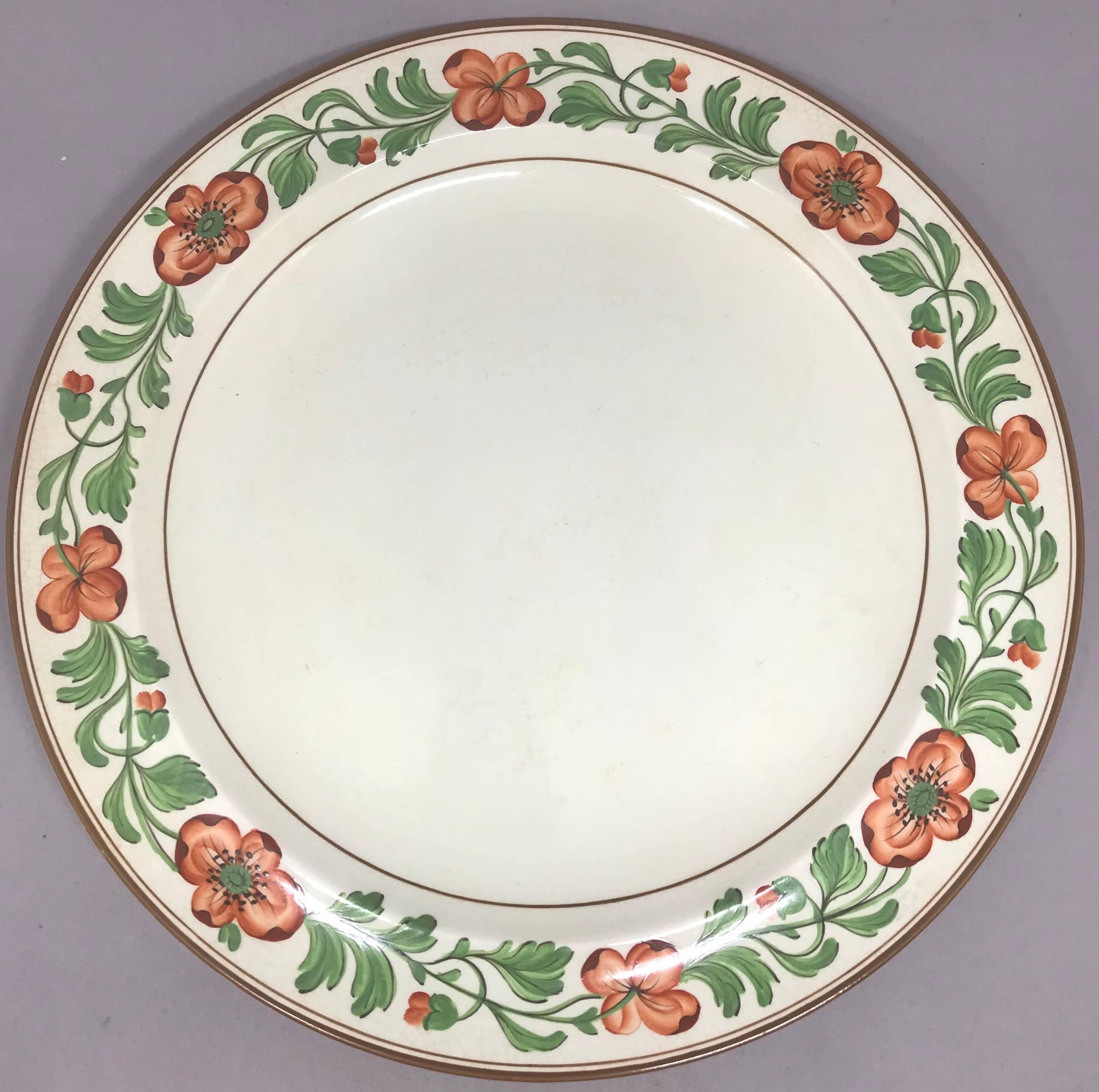 Ensemble de huit assiettes à la crème Wedgwood. Huit grandes assiettes à dîner en faïence crème décorées d'une bordure florale audacieuse peinte à la main en orange et vert avec des bandes brunes ; numéro de modèle A4440 avec marque imprimée pour