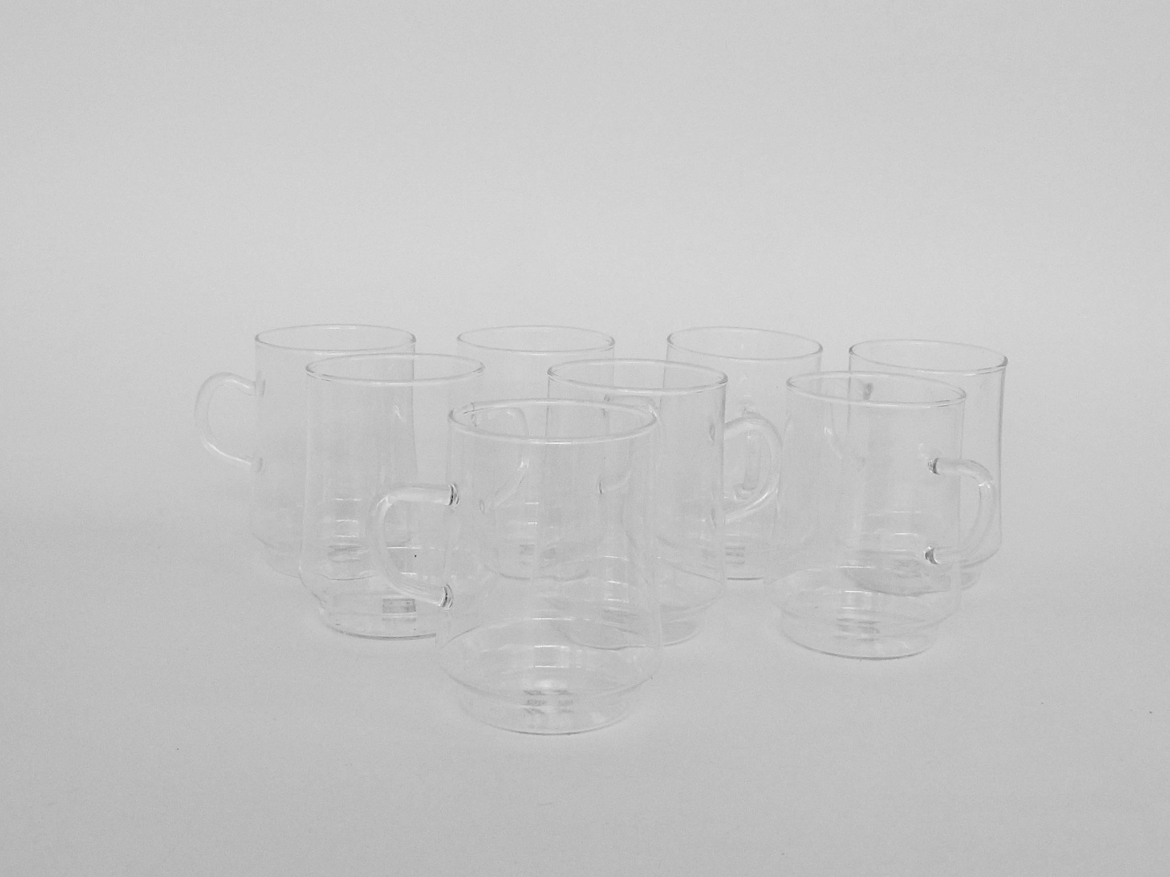 Set of eight tea, coffee or toddy drinks cups with handles. Fine delicate but strong Jena glass taper inward from the bottom upwards.
Jena glass (German: Jenaer Glas) is a shock- and heat-resistant glass used in scientific, technological as well as