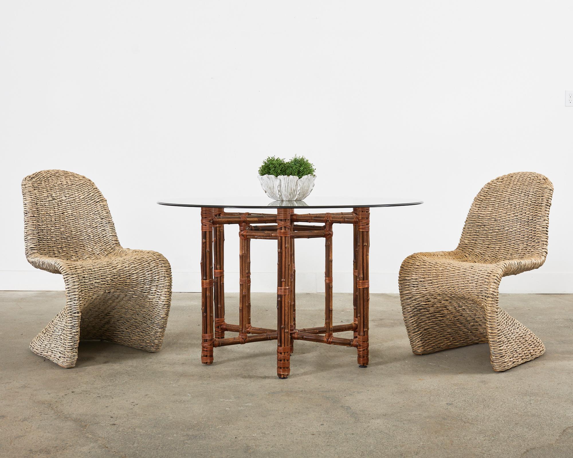 Stylish set of eight woven leaf wicker dining chairs made in the Mid-Century Modern manner and style of Verner Panton. The chairs feature a gracefully curved metal frame completely wrapped with woven leaf wicker. Excellent joinery and craftsmanship