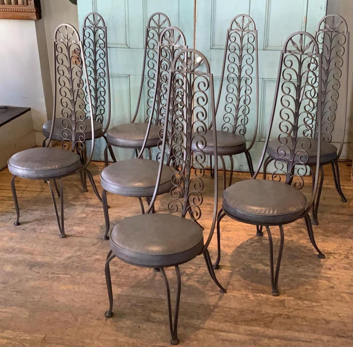 A large set of eight of these amazing 1950's wrought iron dining chairs designed by Arthur Umanoff. Extremely well made and wonderful details, with a double scroll pattern in the tall curved seat back. Curved legs supported cushioned seats. The