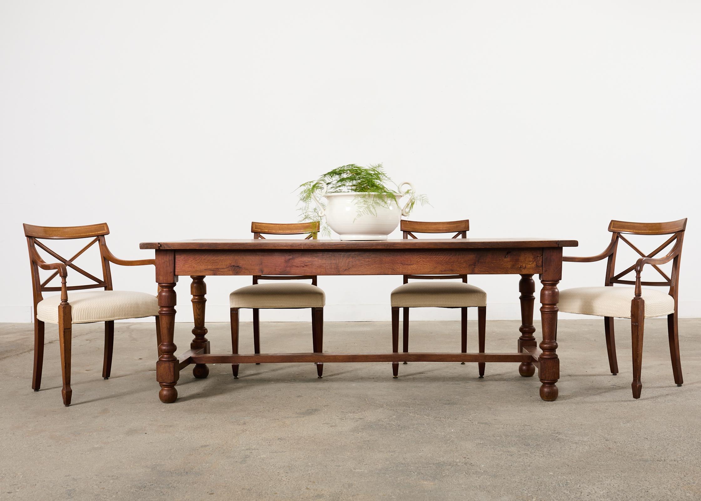 Exceptional and rare set of eighteen English mahogany dining chairs featuring x form neoclassical style splats. The late 19th century chairs have a curved tablet style back inspired by Greco-Roman klismos chairs. The set consists of 16 side chairs