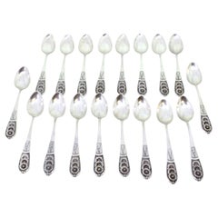 Set of eighteen silver dessert spoons with floral reliefs on the handles