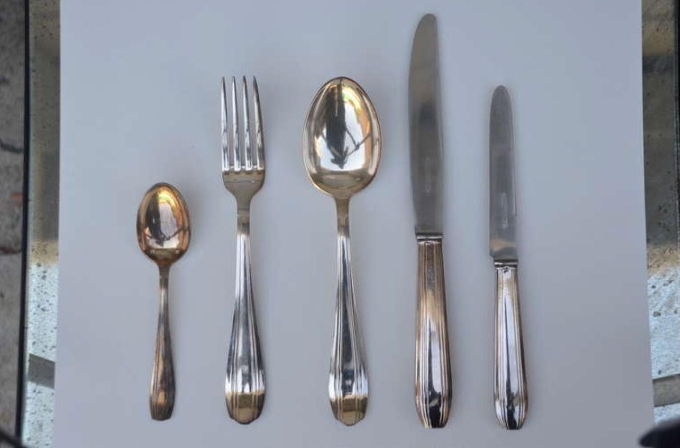 Set of Elegant French Art Deco silver tableware
Quantities:
Knives 12 (length: 10 in.)
Knives (small) 12
Spoons 12
Spoons (small) 12
Forks 12
Serving spoon 1 (12.5 in.)

(Brown) box set measurements:
Height 3 in.
Width 14 in.
Depth 12 in.

(Blue)