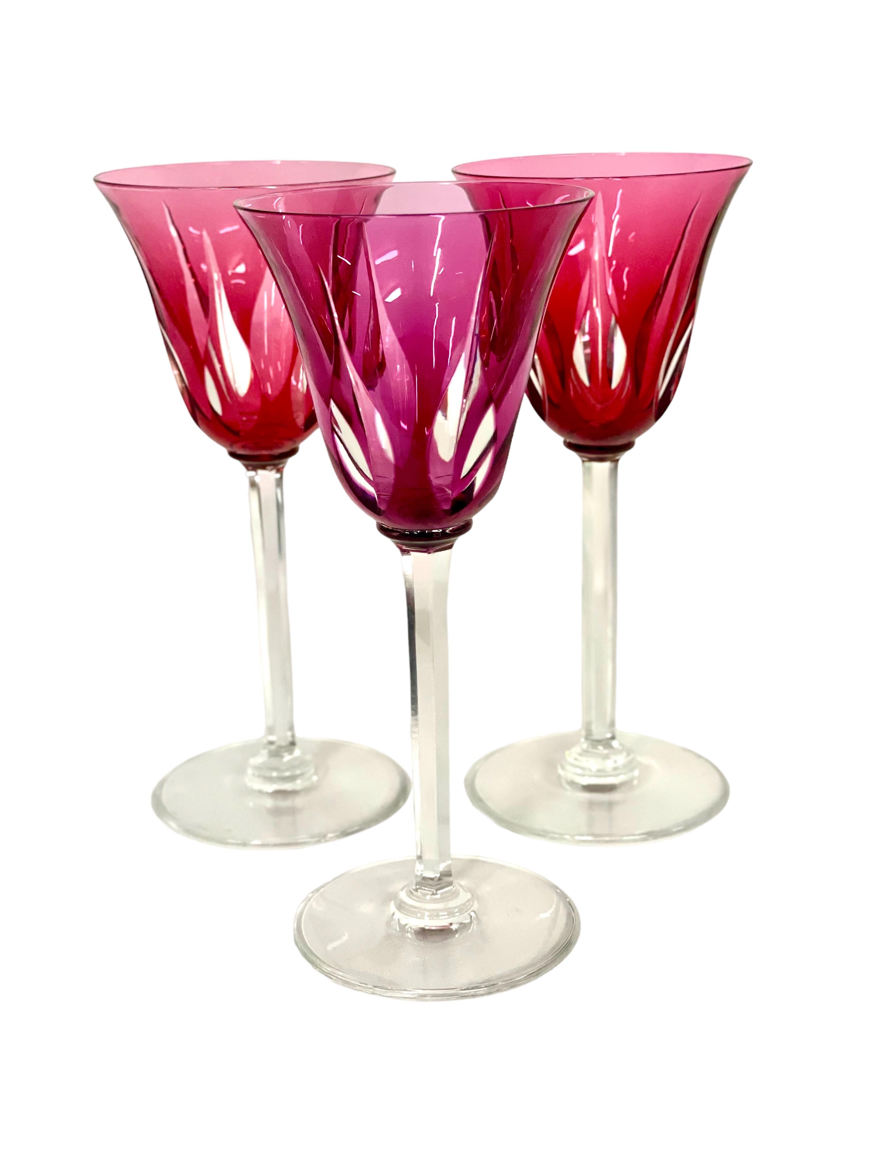 A riotously colourful set of eleven Rhine wine, or 'Roemer', glasses in sparkling Saint-Louis crystal. The tulip-shaped chalice of each is cut to clear with tall and pointed lozenges, while the stem features elegantly cut flat ribs. The glasses are