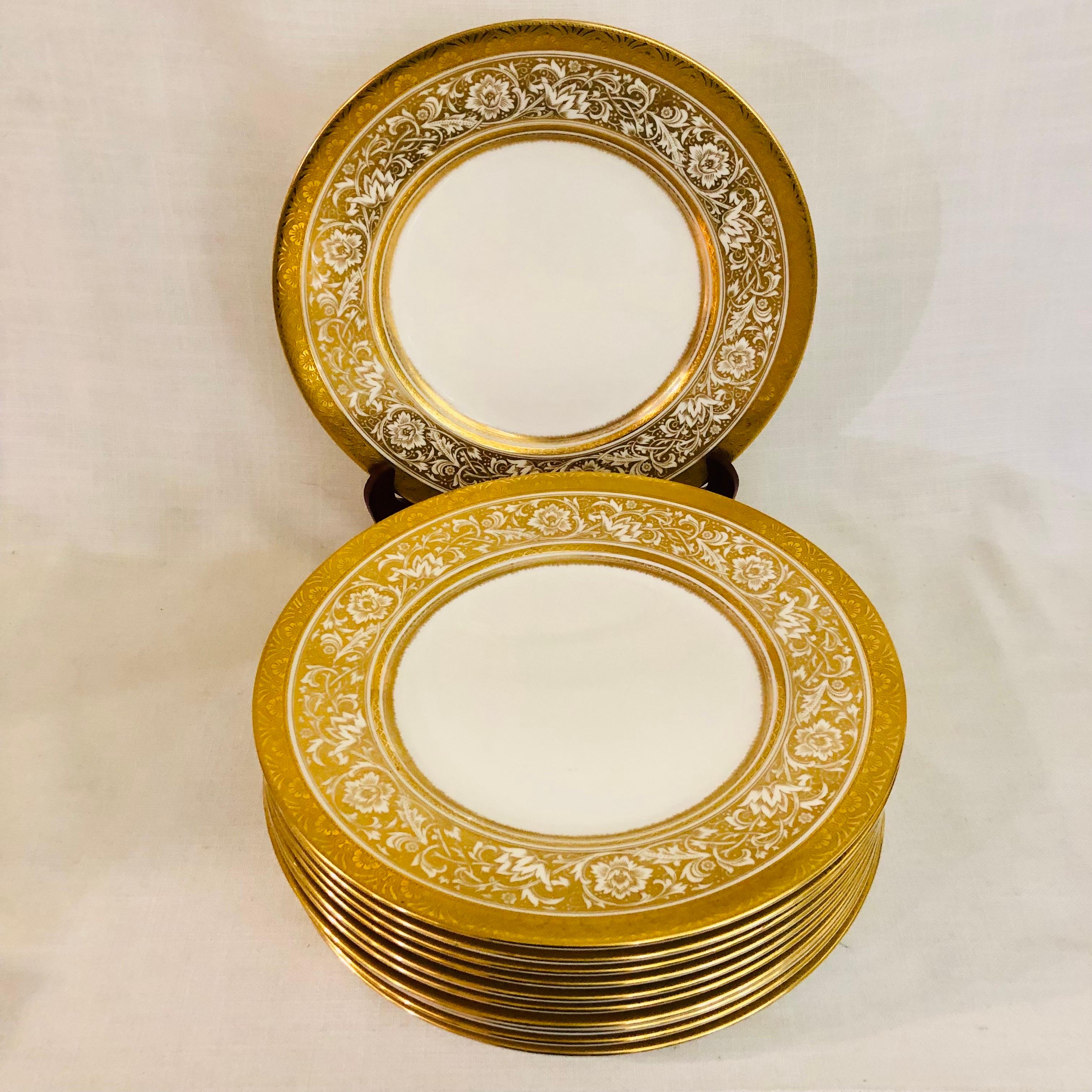 Dies ist ein exquisiter Satz von elf Minton Porcelain Ball Esstellern. Sie haben ein wunderschönes goldenes und weißes Arabeskendekor aus Blumen mit einem geprägten, vergoldeten Rand. Diese Minton-Porzellan-Kugelteller wurden exklusiv für die