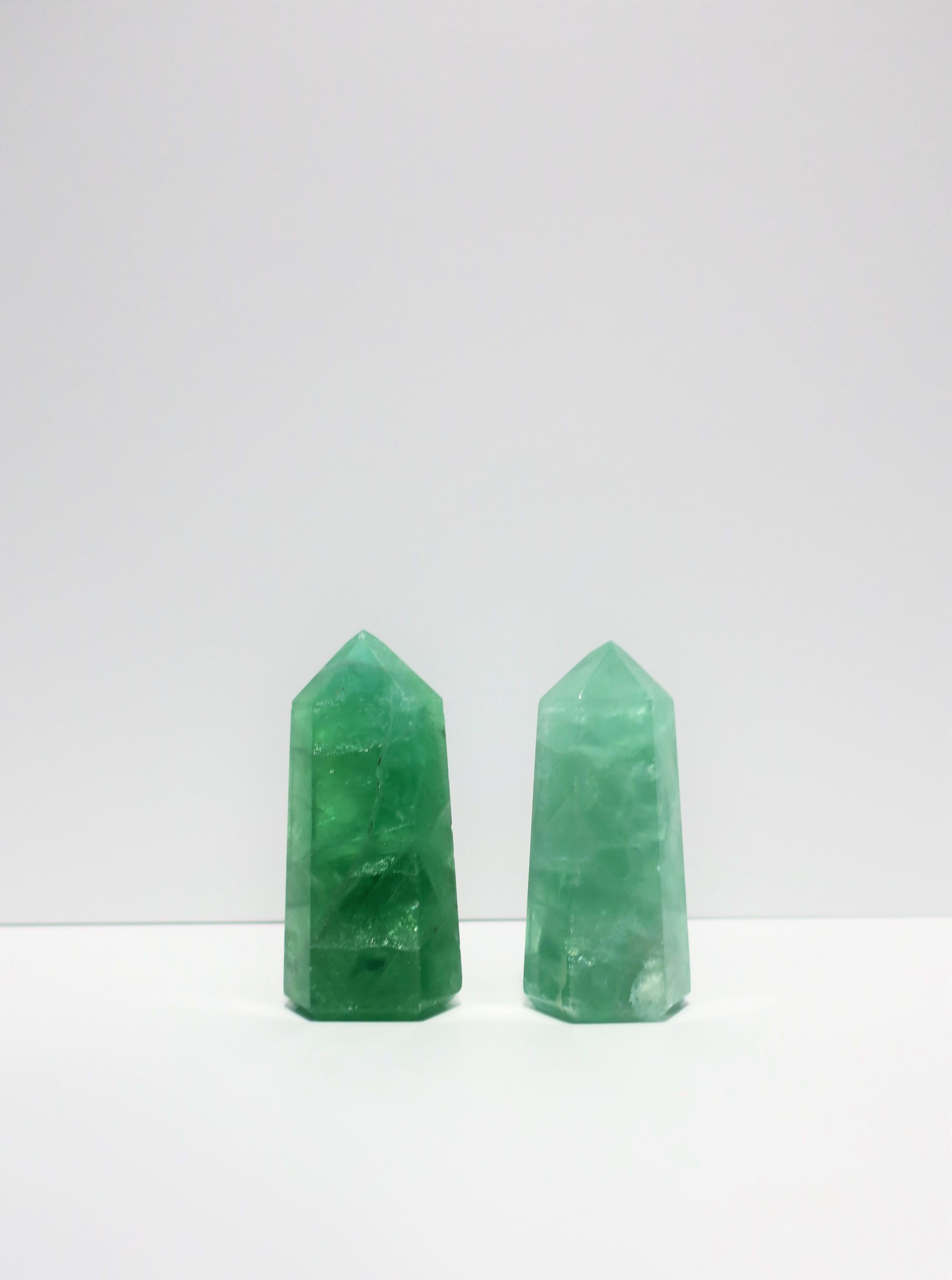 A beautiful pair of Modern style Emerald green quartz crystal decorative objects/sculpture pieces in a hexagon shape/form. Pieces, similar to an obelisk, are made of a single piece of crystal quartz with a pyramid-like form top. 

Measurements:
L