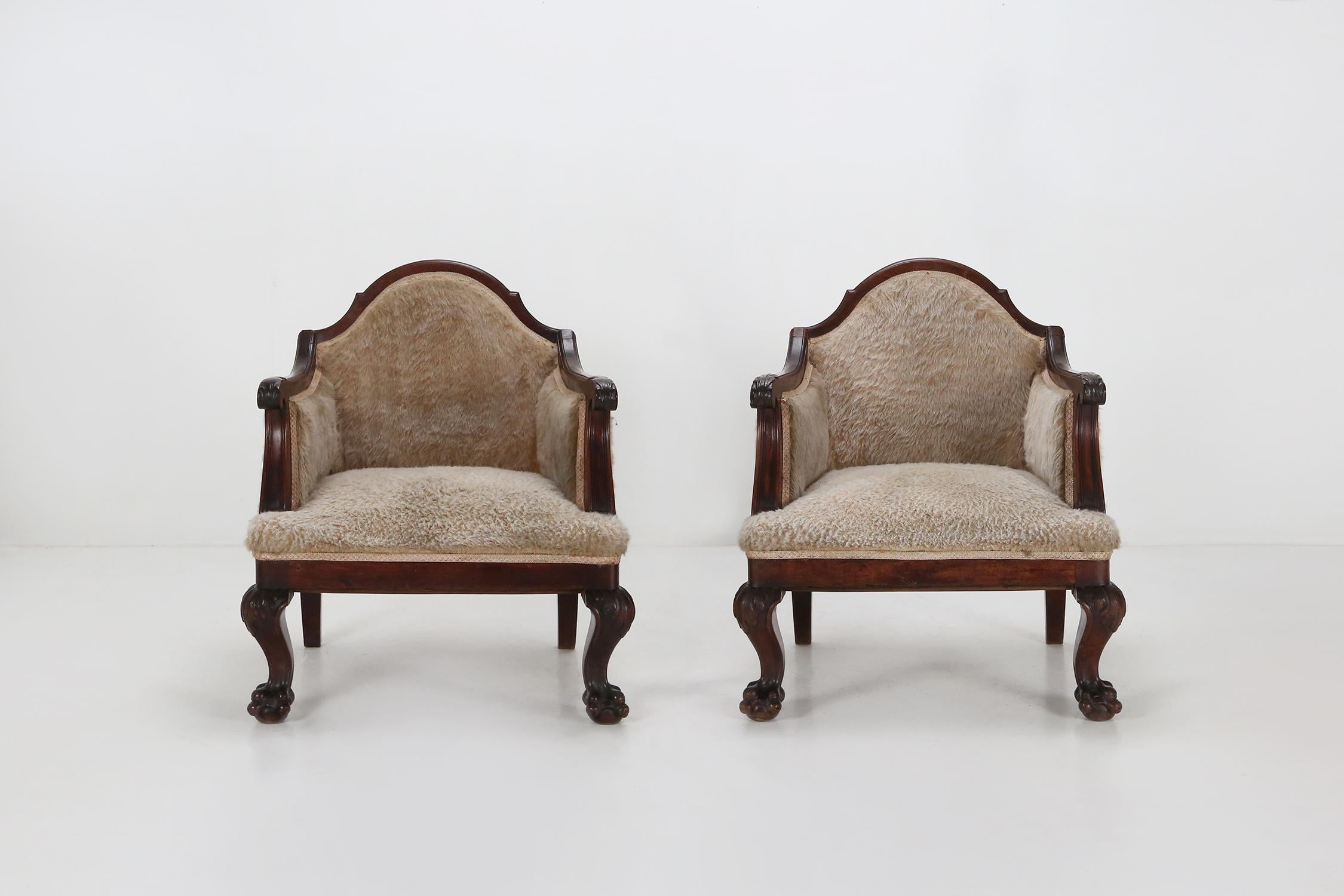 Set of two early Empire armchairs made of solid mahogany wood and sheepskin.
With carved sculptured armrests and lion's paw feet to the legs.
A great patina on this set of French seats gives them a fantastic look and feel.