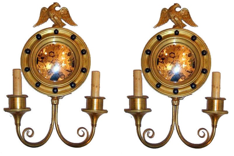 Set of four circa 1920s American gilt bronze sconces with mirror inset in the backplate and eagle atop. Sold per pair.

Measurements:
Height: 17.5