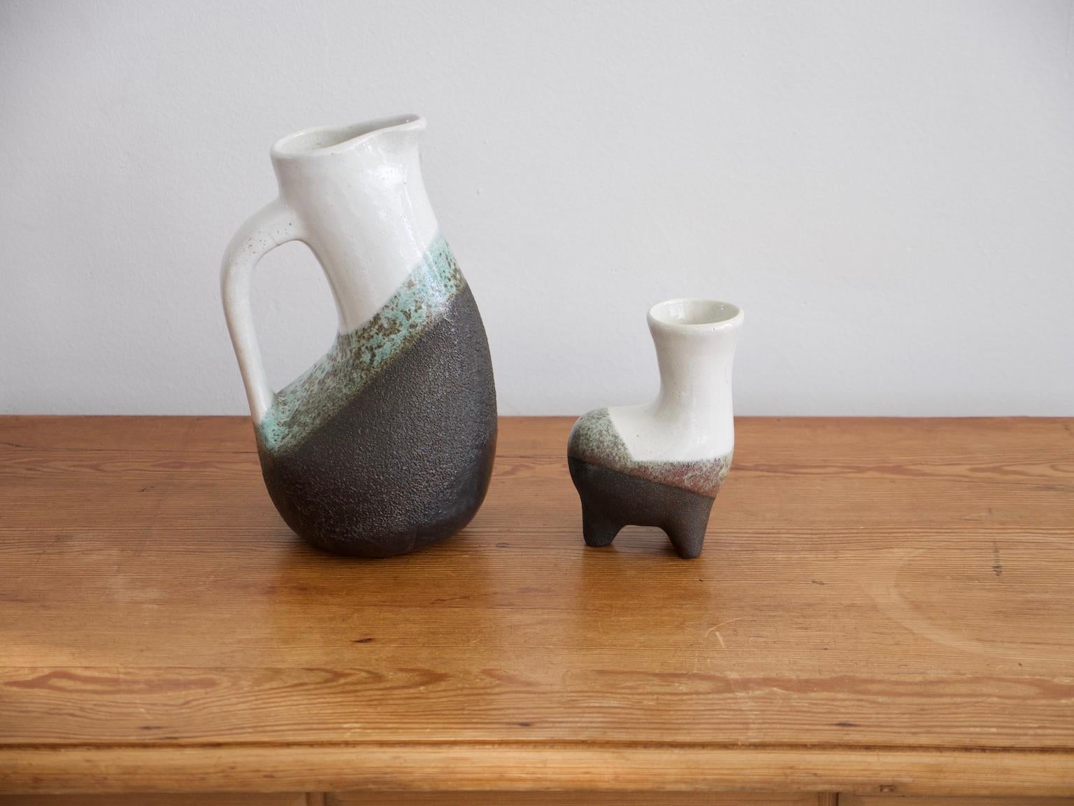 Una grande brocca e un vaso più piccolo di forma zoomorfa realizzati in terracotta smaltata dal ceramista, pittore e scultore francese Gilbert Valentin (1928-2001).
Misure: Caraffa H 31,5 cm, L 17,5 cm, P 16,5 cm.
Vaso H 17,3 cm, L 11,5 cm, P 8,5 cm.