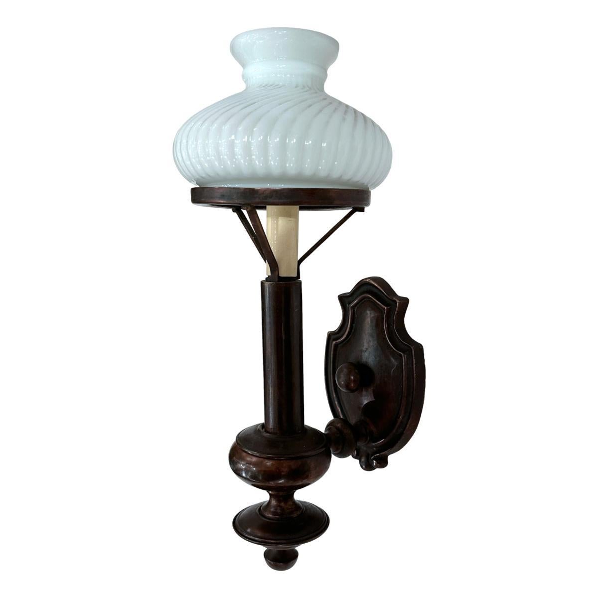 Set di 10 appliques neoclassiche inglesi degli anni '50 circa, in bronzo patinato e con paralumi in vetro opalino. Venduto al paio.

Misure:
Altezza: 15