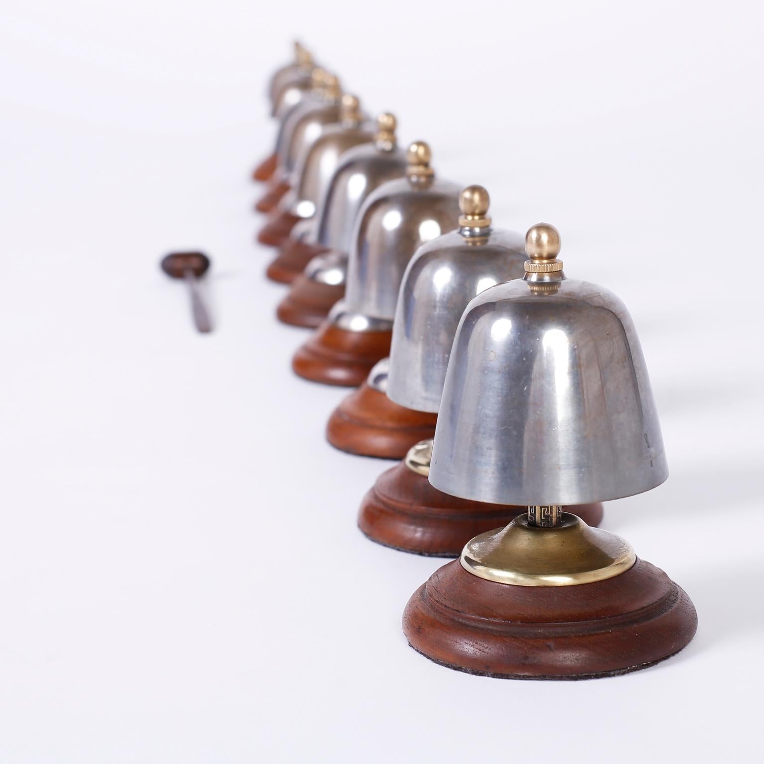 Intriguing antique set of nine bells crafted in steel with a crisp clear ring in the scale of a major. Featuring brass posts with Greek key designs, brass caps and finials, hand carved mallet and turned mahogany bases.

Bell heights range from 4.5