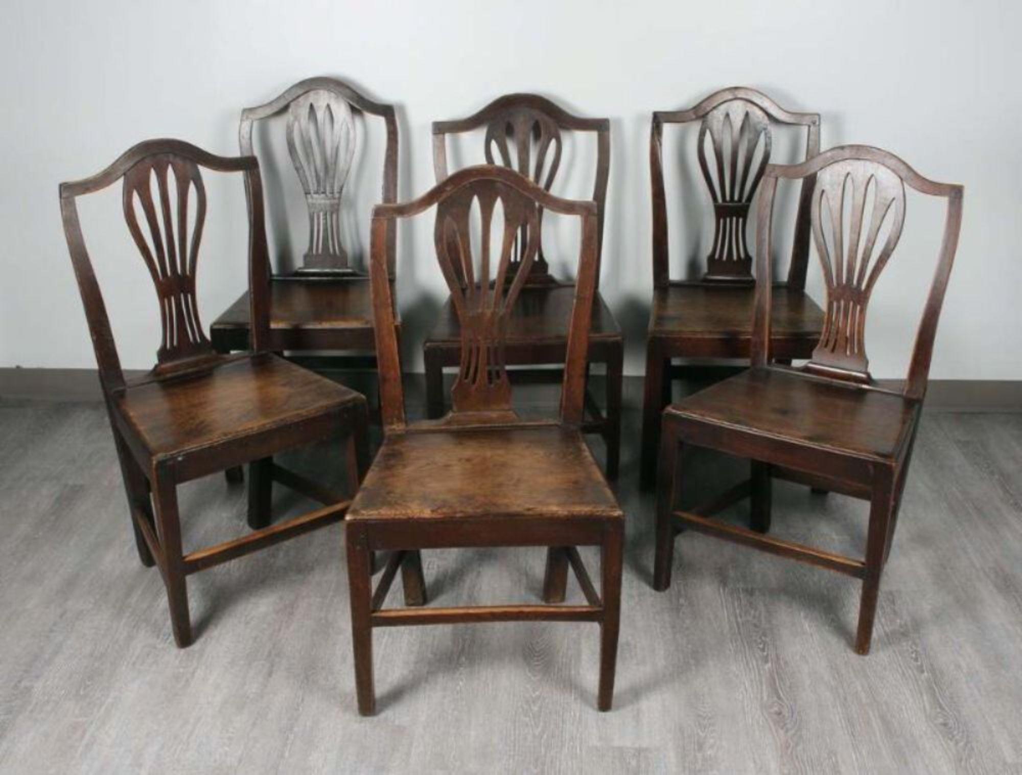 Good assembled set of English country oak Hepplewhite chairs having shield crests over pieced back splats over plank seats, over square tapered legs joined by box stretchers, all of the same design with slight variations in height, but all with good