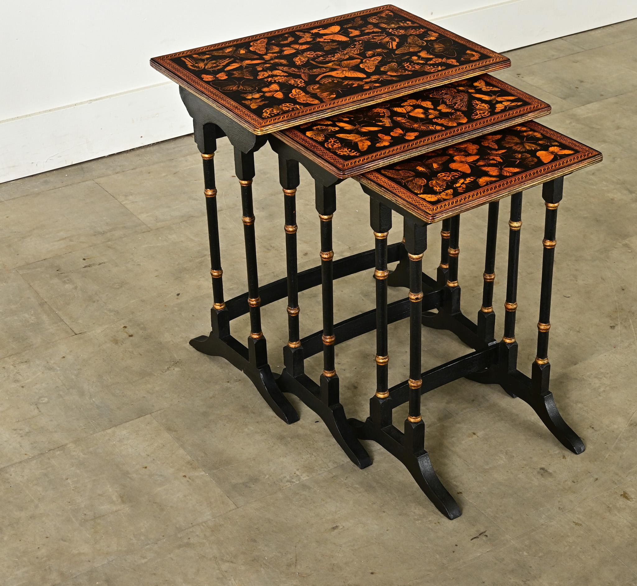 Functional and fun, here is a set of three, 20th century English nesting tables that have received an ebonized (painted) finish and decoupage butterflies on the table tops. The honey-gold butterflies are matched in tone by the painted gold details