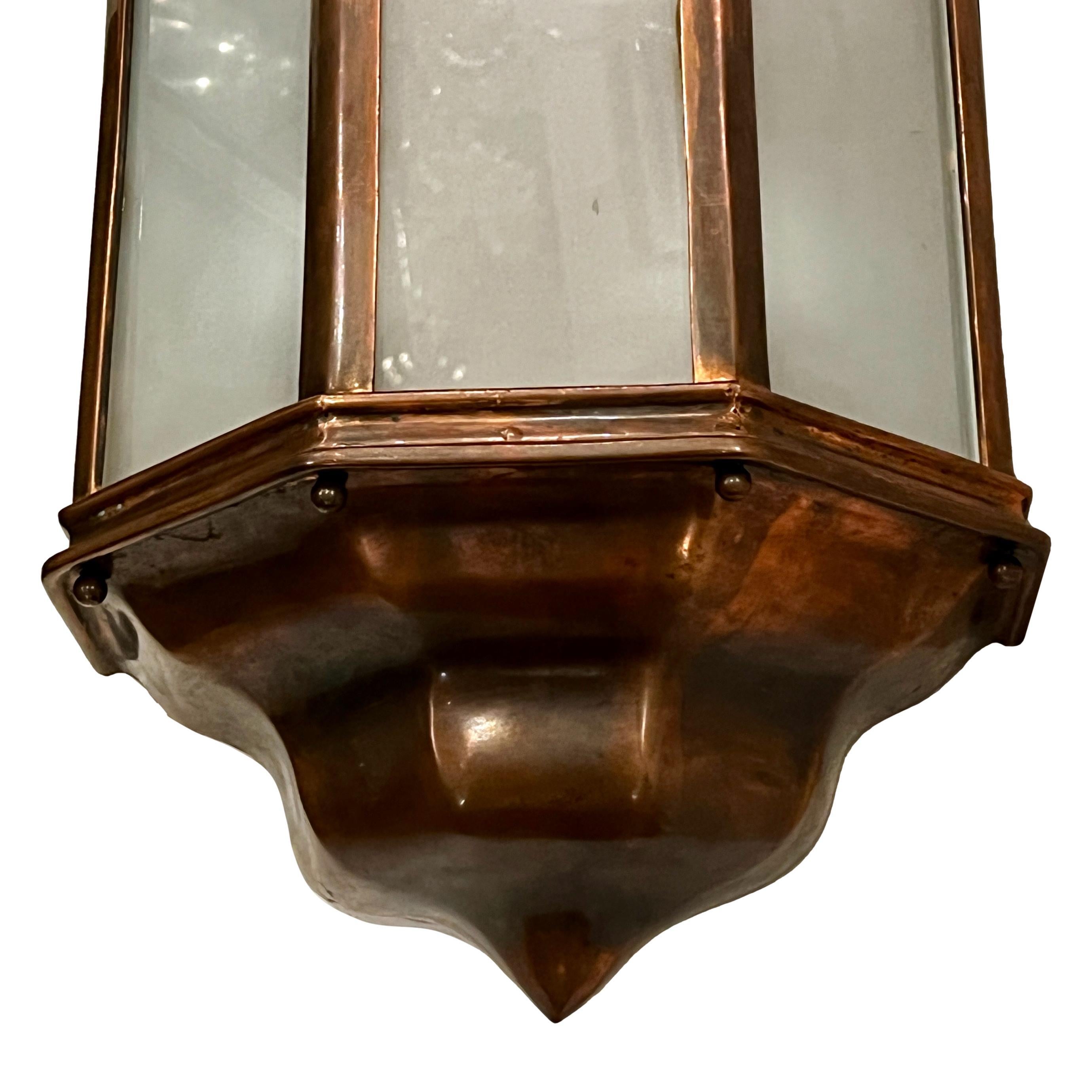 A set of twelve English circa 1940's indoor/outdoor copper sconces with frosted glass panels and interior lights. Sold per pair.

Measurements:
Height: 18