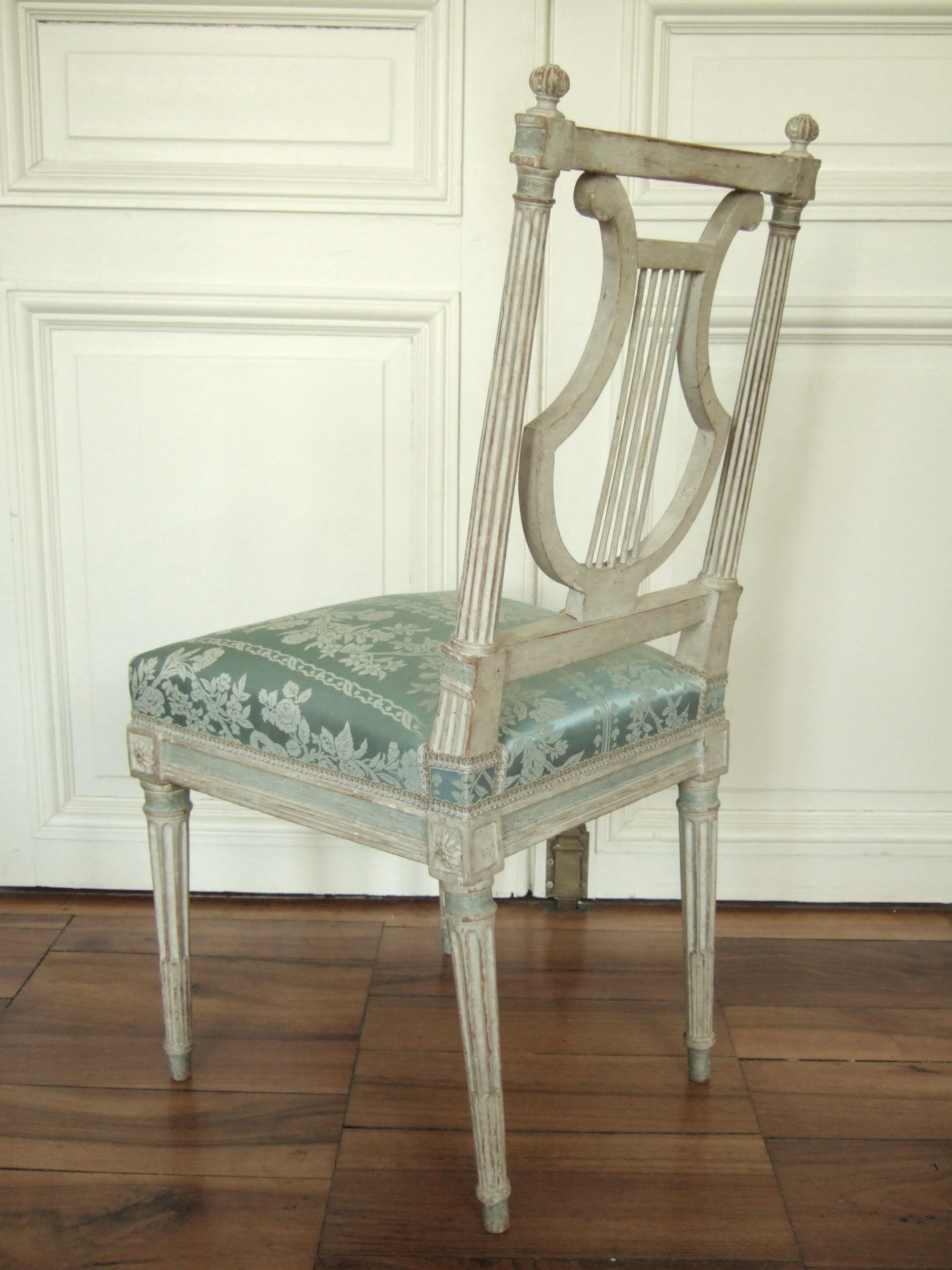 Exceptionnelle série de chaises lyre Louis XVI en bois laqué, modèle prisé et symbole de raffinement au XVIIIe siècle. Bien que ces chaises ne soient pas estampillées, leurs détails rappellent fortement une production de Jacob : une sculpture