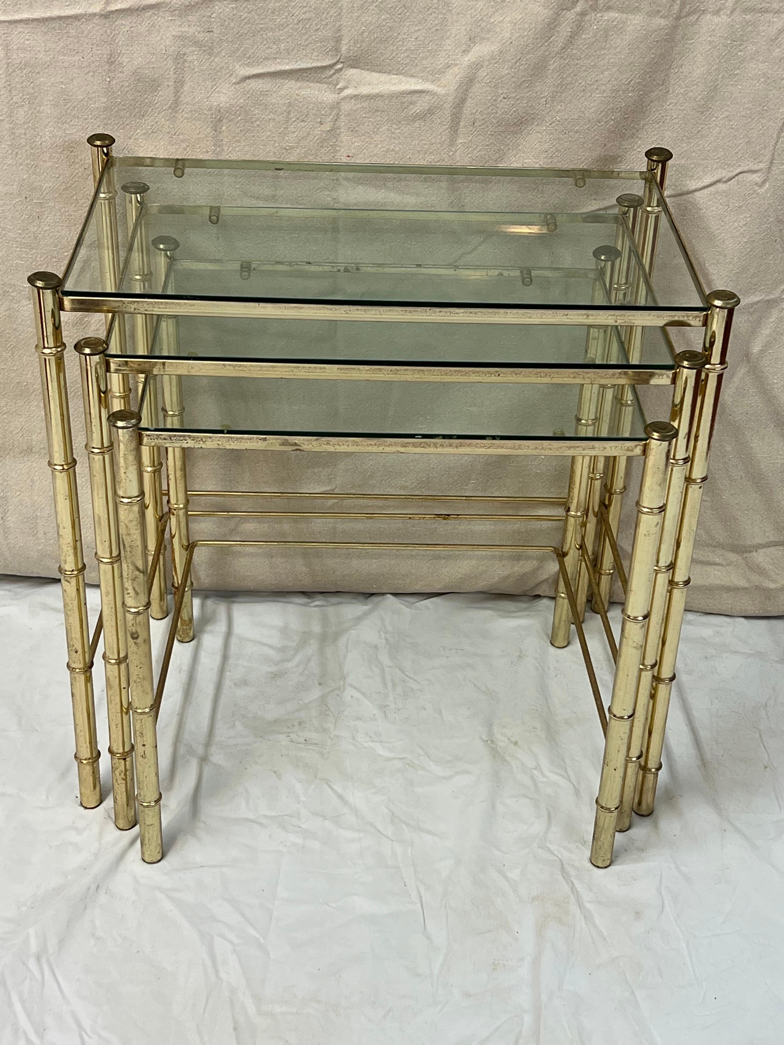 Set of Faux Bamboo Brass nesting Tables. Three total with clear glass. Perfect for small spaces. Use together or use apart. Some pitting to the brass plated finish. This item can parcel ship in the continental US for under $100