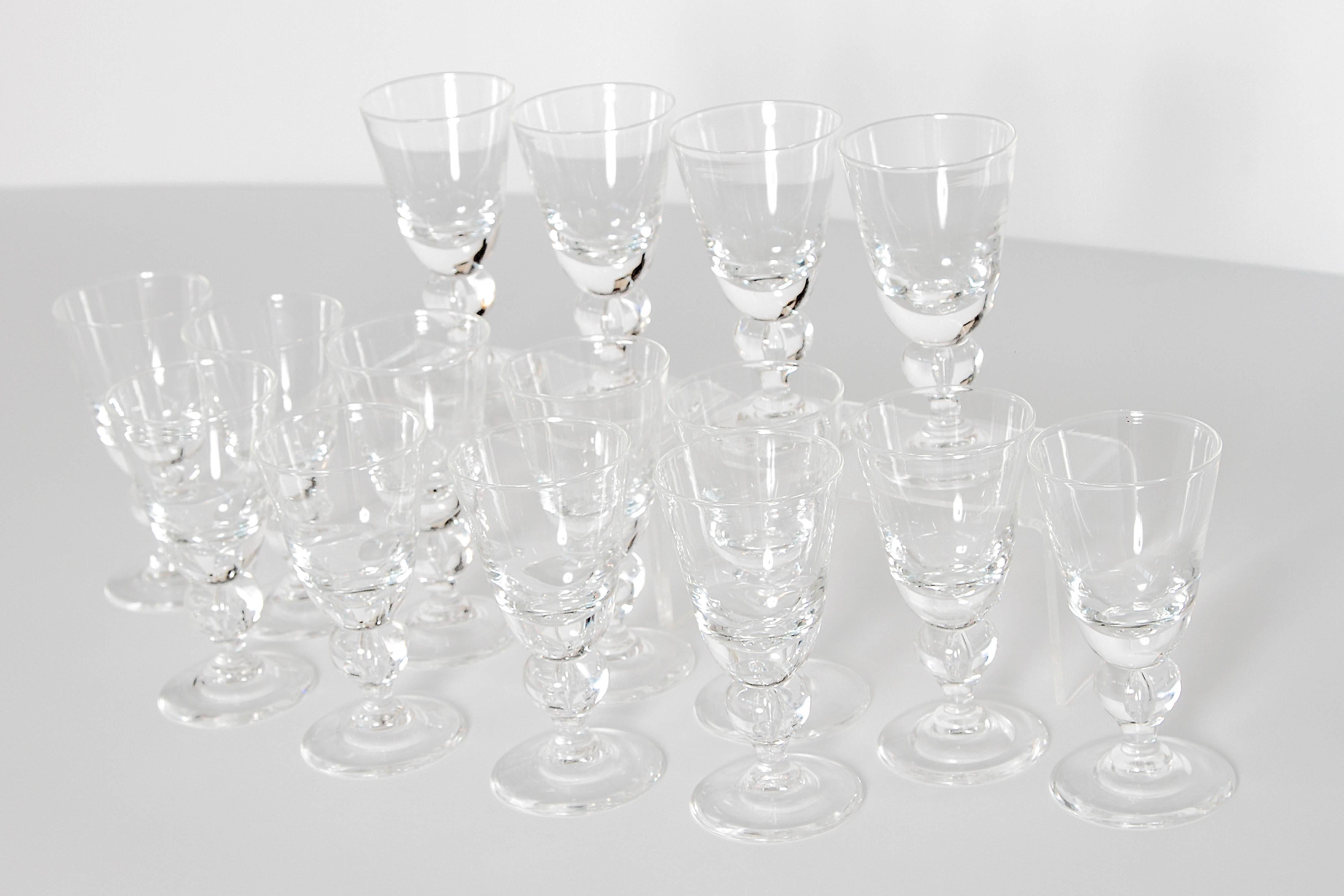 A set of 15 water goblets designed by George Thompson for Steuben Glass Works. The design is known as #7877 and was introduced in 1940. The goblets feature a baluster know in the stem with a captured bubble reminiscent of those used in Colonial