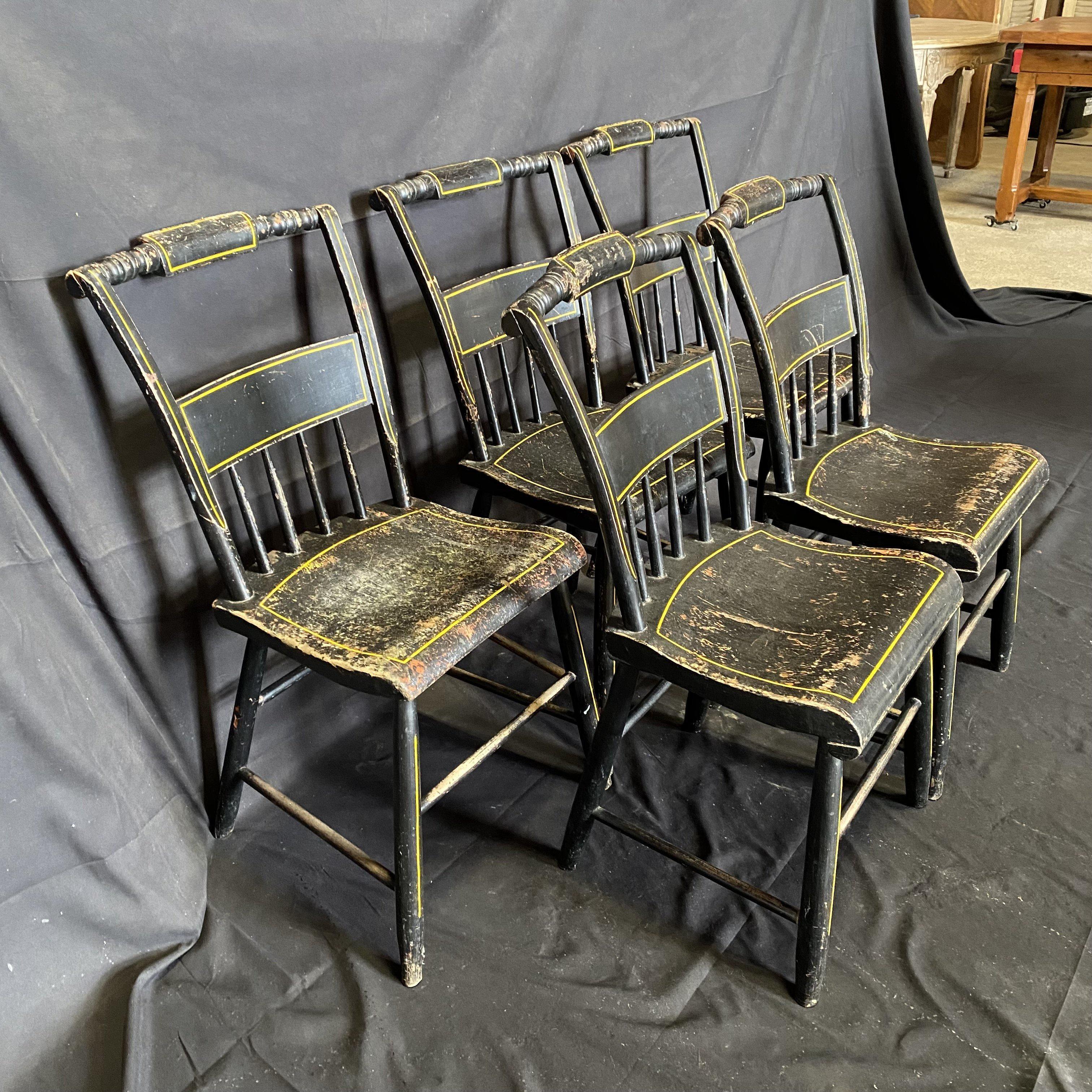 Set of five paint decorated, plank seated chairs, in original black paint, decorated with simple but beautiful yellow striping from Maine. The paint surface is original and untouched. There are minor scrapes and losses, but adds to the character and