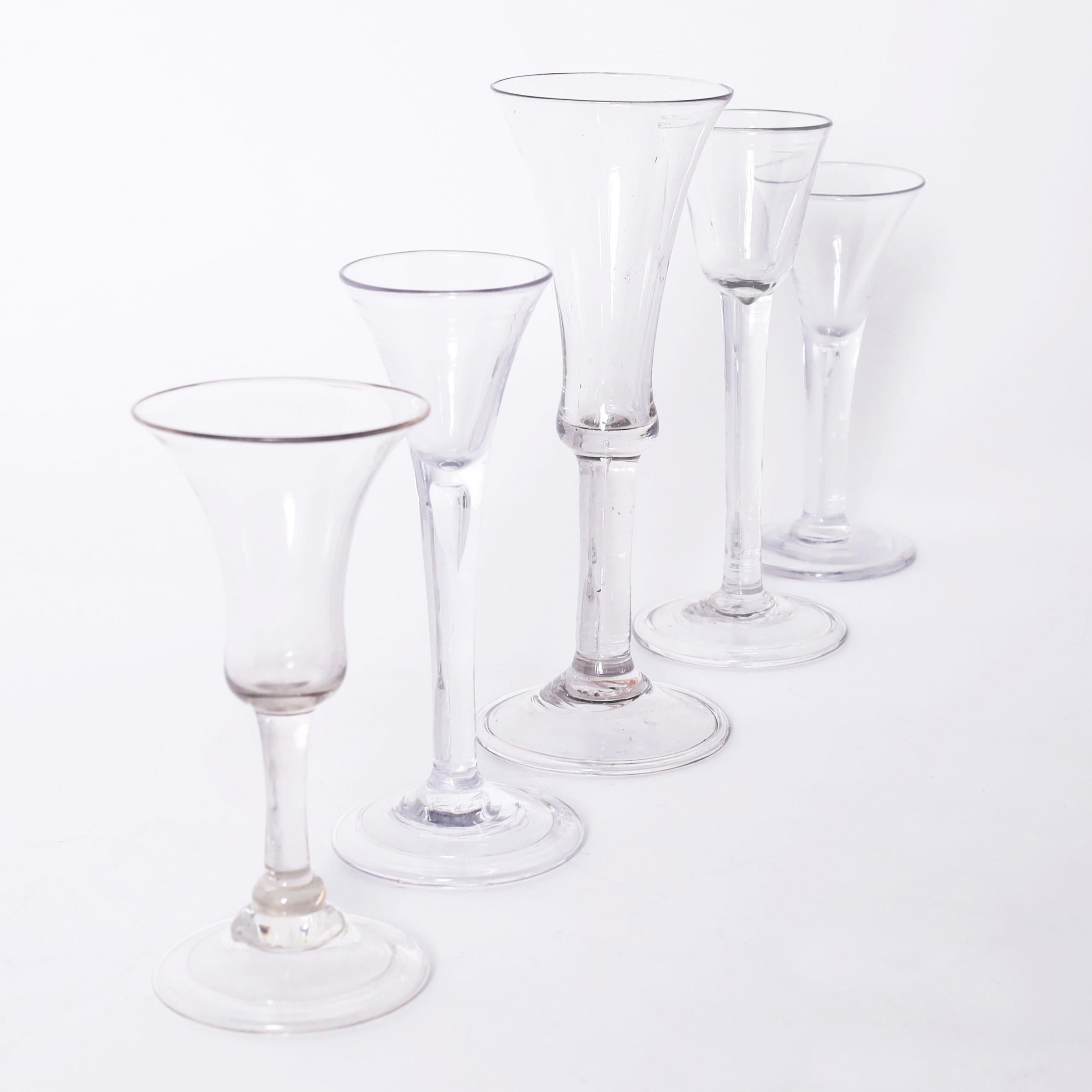 Rare and remarkable set of five hand blown folded and domed foot plain stem wine or liquor glasses in assorted sizes and classic elegant forms.

From left to right:

H: 5 DM: 2.5
H: 6 DM: 2.5
H: 7.5 DM: 3
H: 6.5 DM: 2.5
H: 5.5 DM: 2.5