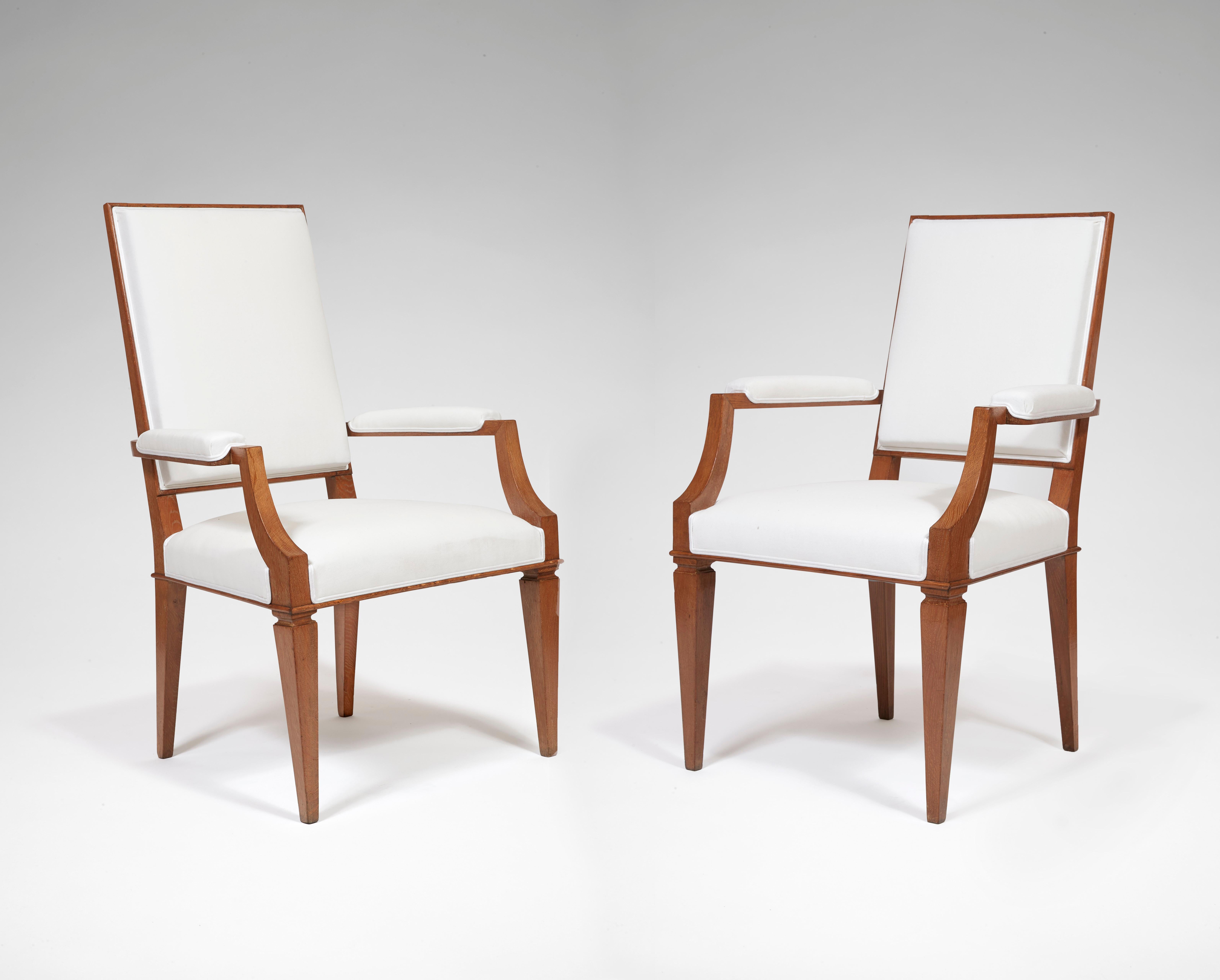 In ceruse oak wood, tapered legs with an ornate frieze at the top, conical at the front and slightly sabre at the back, the backs and the seats covered with white fabric. Sell as pairs, two pairs available and one single.

Furniture created by André