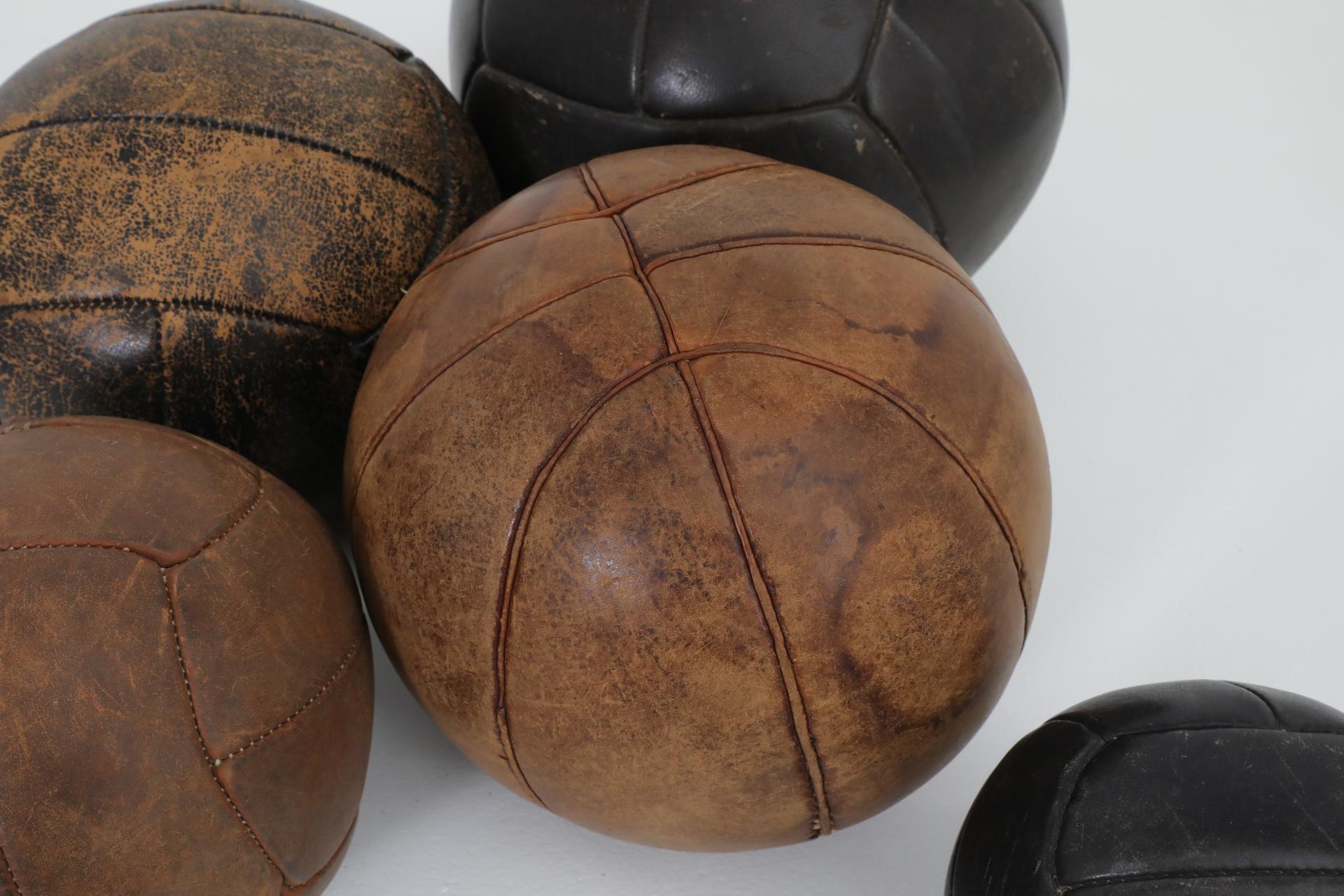 Juego de cinco balones medicinales de gimnasia de cuero vintage surtidos siglo XX en venta