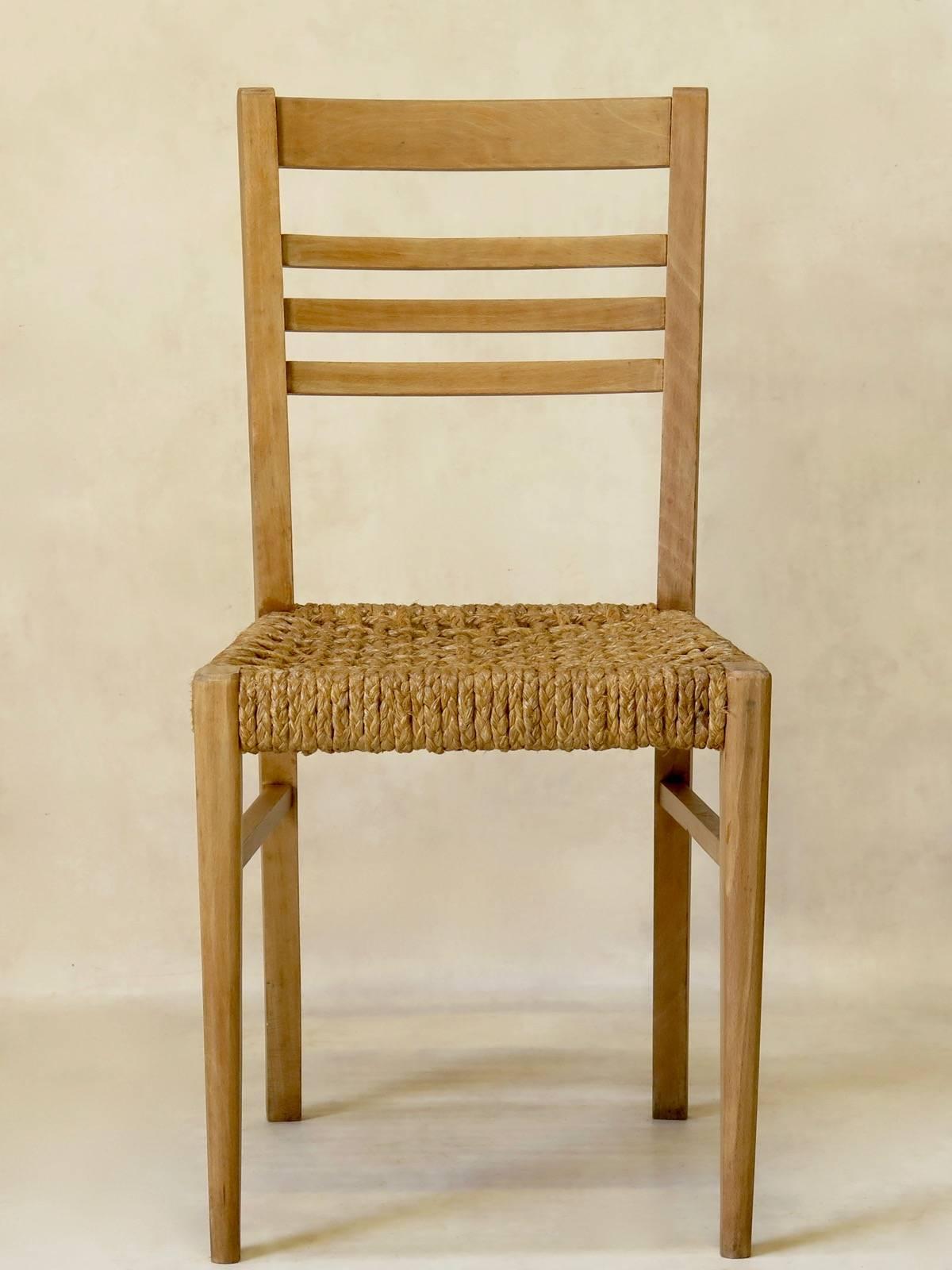 Minimalist set of five beechwood dining chairs, attributed to Adrien Audoux and Frida Minet, with rope seats, simple ladder backs, and tapered legs.