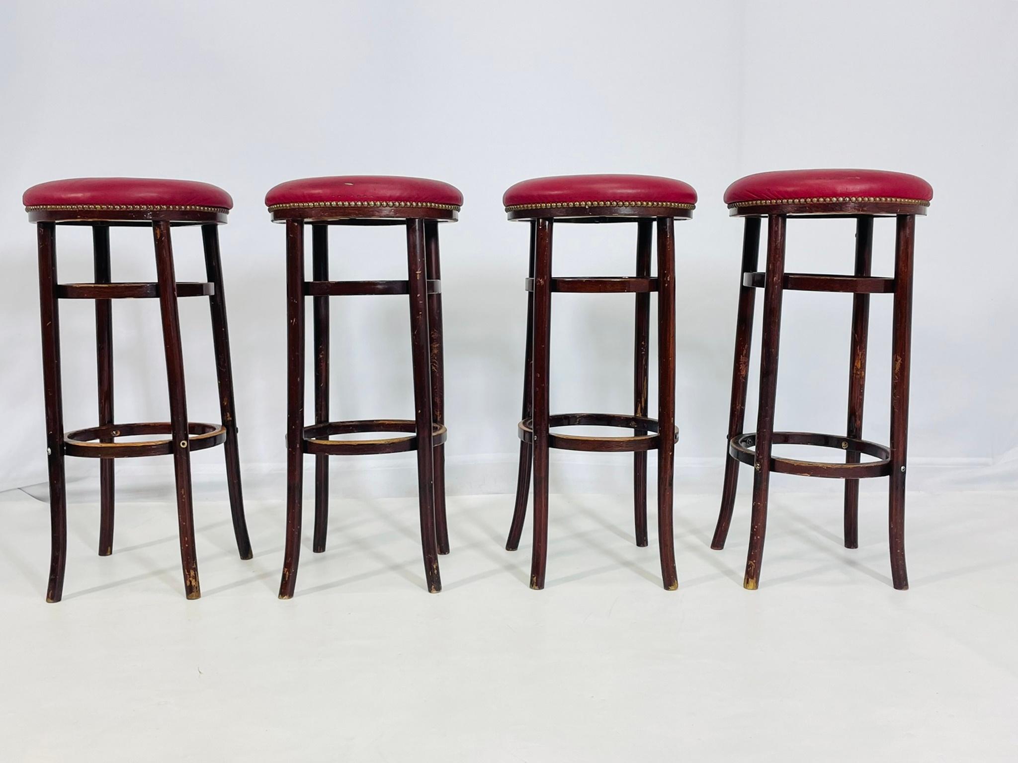 Ensemble vintage de quatre tabourets de bar conçus et fabriqués par Michael Thonet pour Thonet Furniture.
Les tabourets sont fabriqués en bois courbé massif et recouverts de Naugahyde rouge et de clous métalliques tout autour de l'assise.

Les
