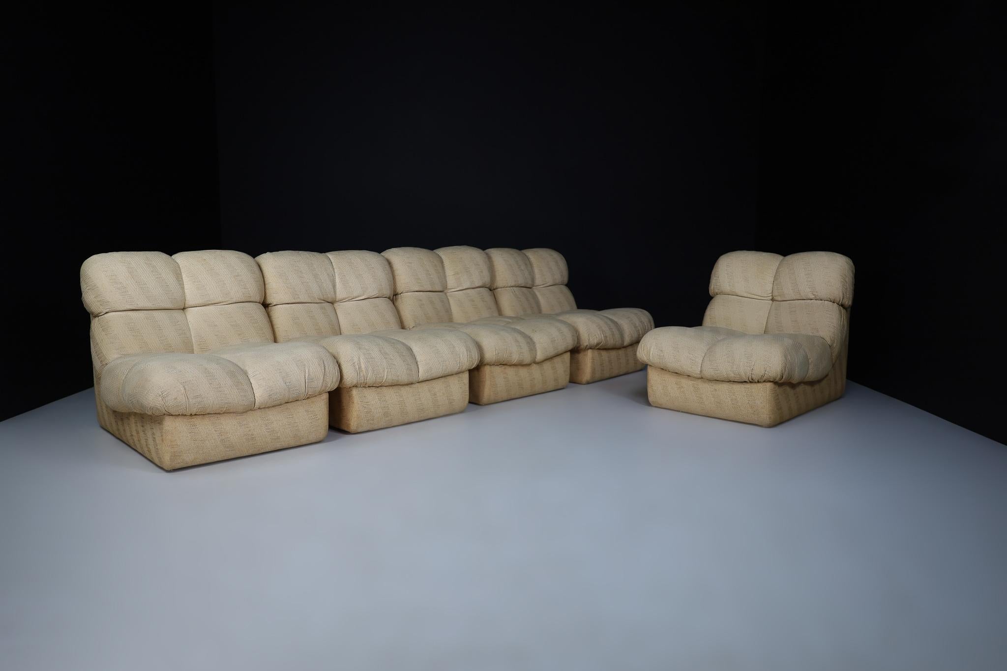 Set of Five Beige Fabric Mid century lounge chairs/sofa, Italy 1970

This design is characterized by an L-shaped form based on two connected tufted cushions. That gives the chair a voluminous and playful appearance. We currently have five items in