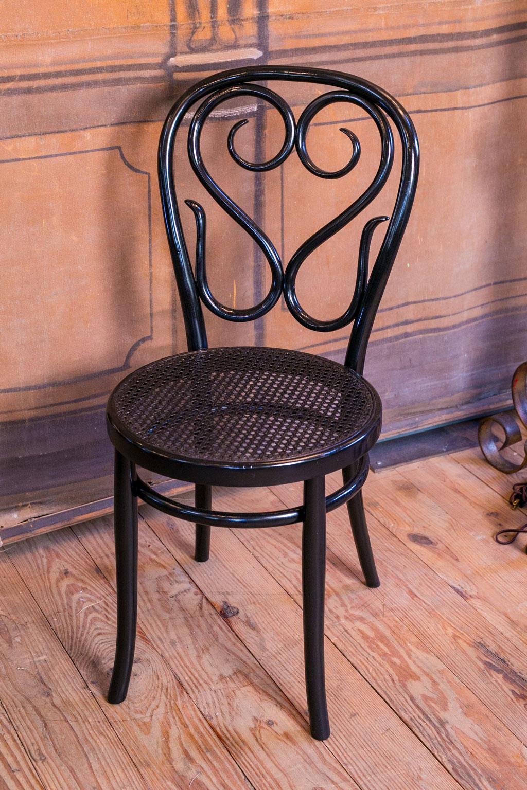 Set of five bentwood bistro chairs with cane seats. These Italian chairs are adorned in an ebonized finish and date to about the 1940s. Sold together as a set of five for $1,550.