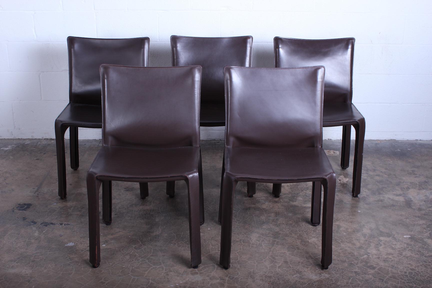 A set of five brown leather cab chairs designed by Mario Bellini for Cassina.