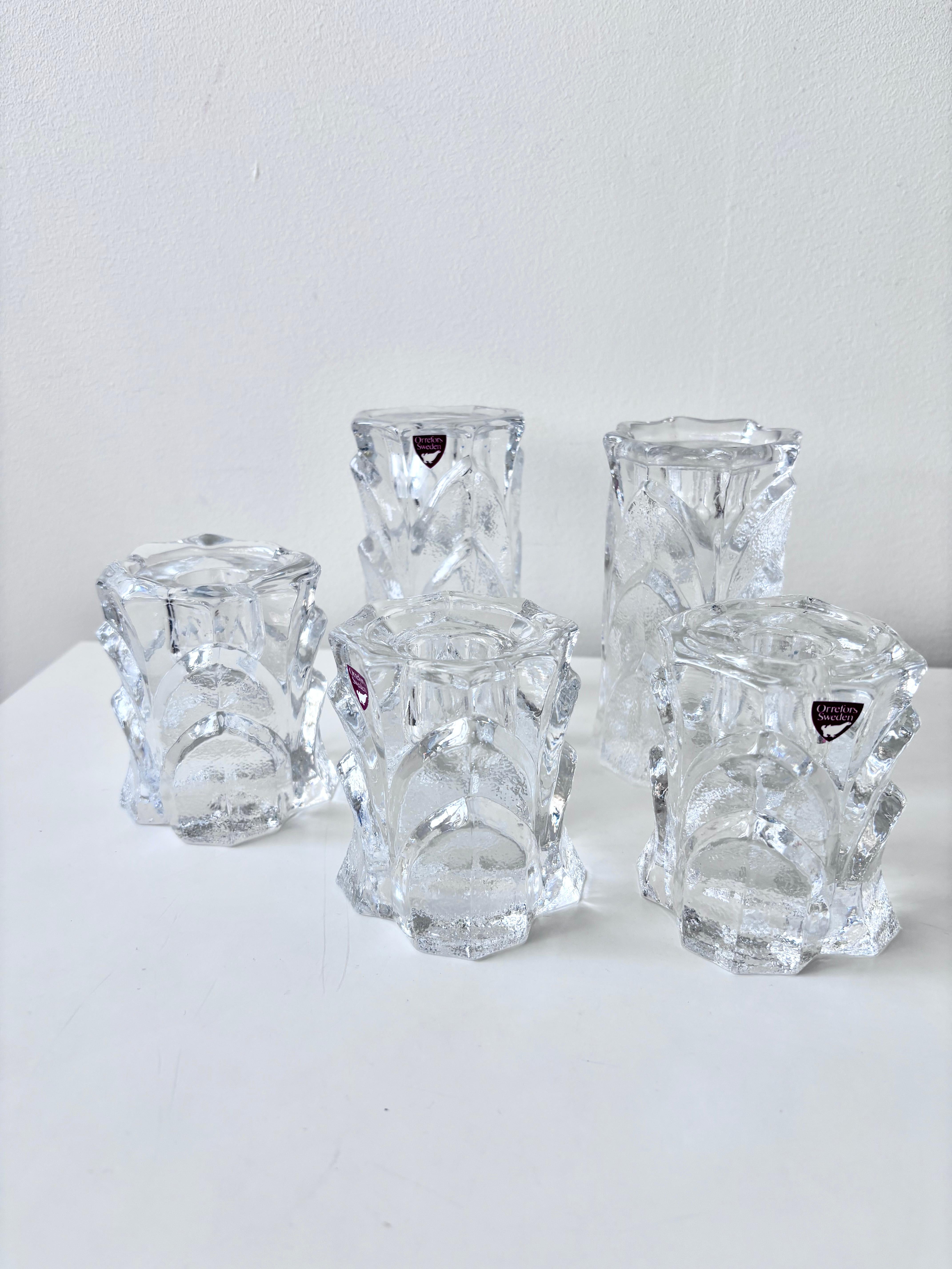 Elegant set of five crystal candle holders from the Capella series, designed by Lars Hellsten for Orrefors, Sweden, during the 1970s. This iconic Scandinavian design showcases Orrefors’ signature craftsmanship and clarity of crystal.

The set