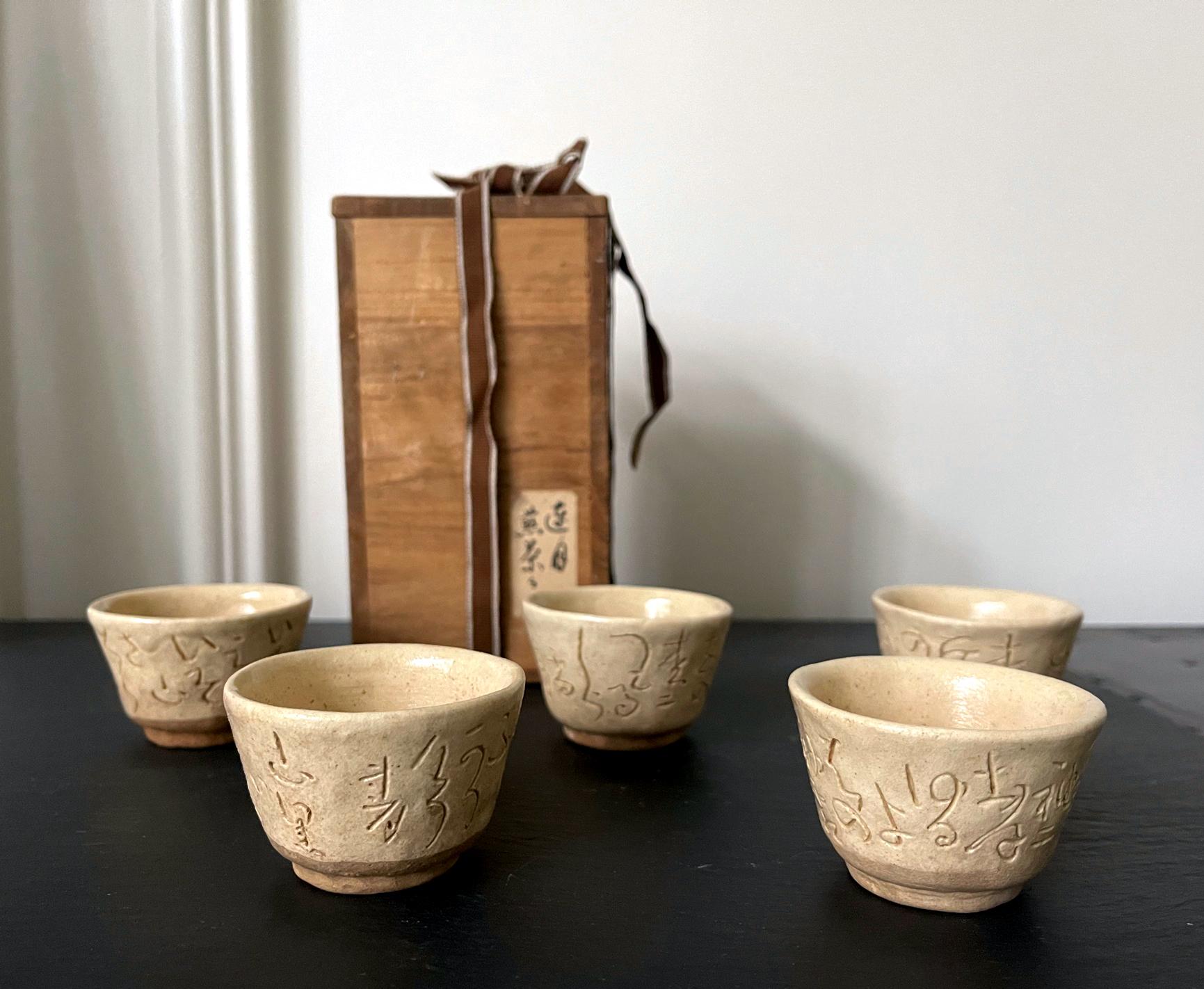 Ein Satz von fünf Sencha-Tassen aus Steinzeug von Otagaki Rengetsu (1791-1875). Diese Miniaturbecher wurden einfach in der klassischen Form gegossen, weiß glasiert und mit kursiven Waka-Gedichten versehen, einem charakteristischen Dekorationsstil