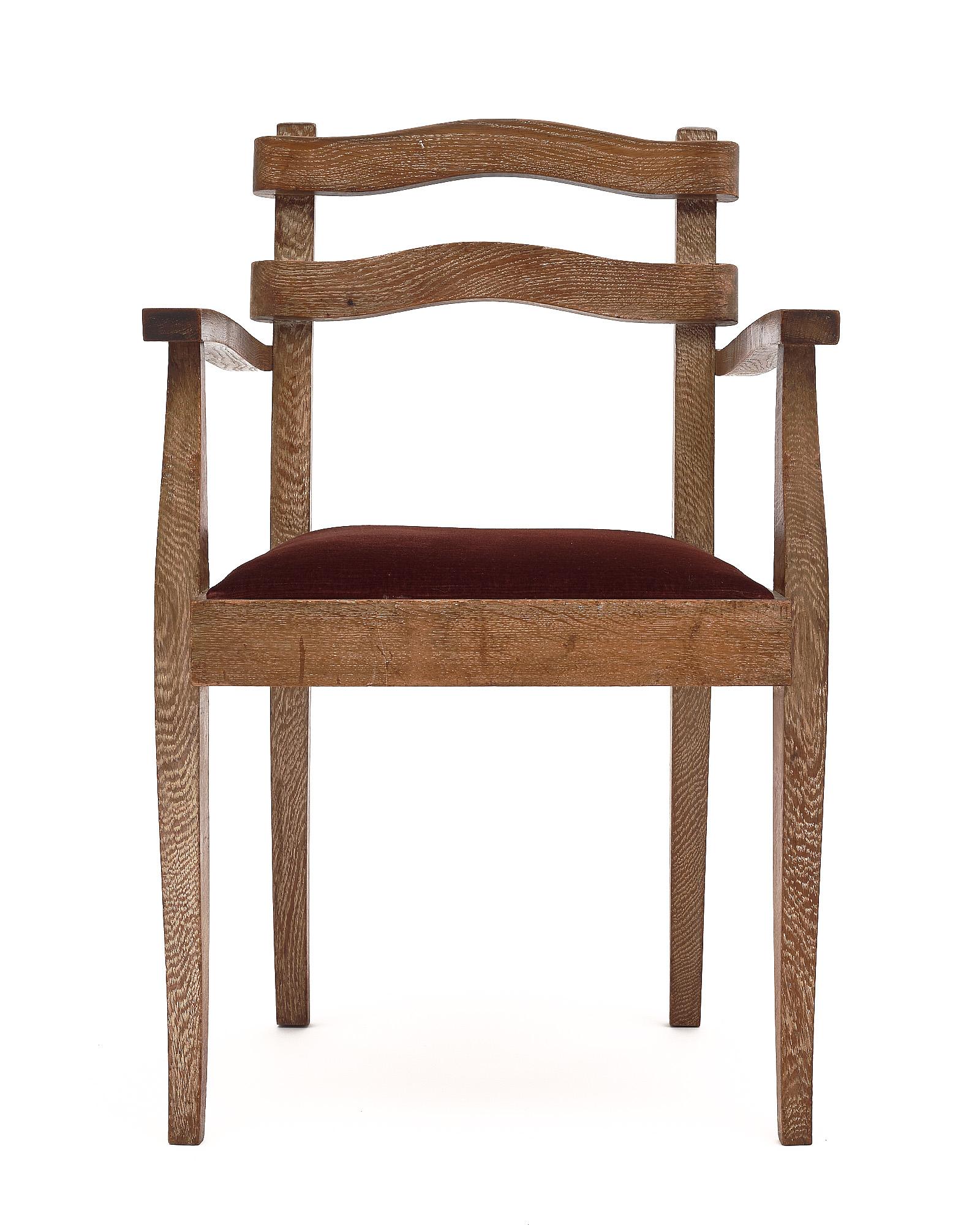 Set of five dining chairs with arms. These chairs are made of solid oak with a unique cerused finish to the wood. The seats are upholstered in the original burgundy colored velvet blend.