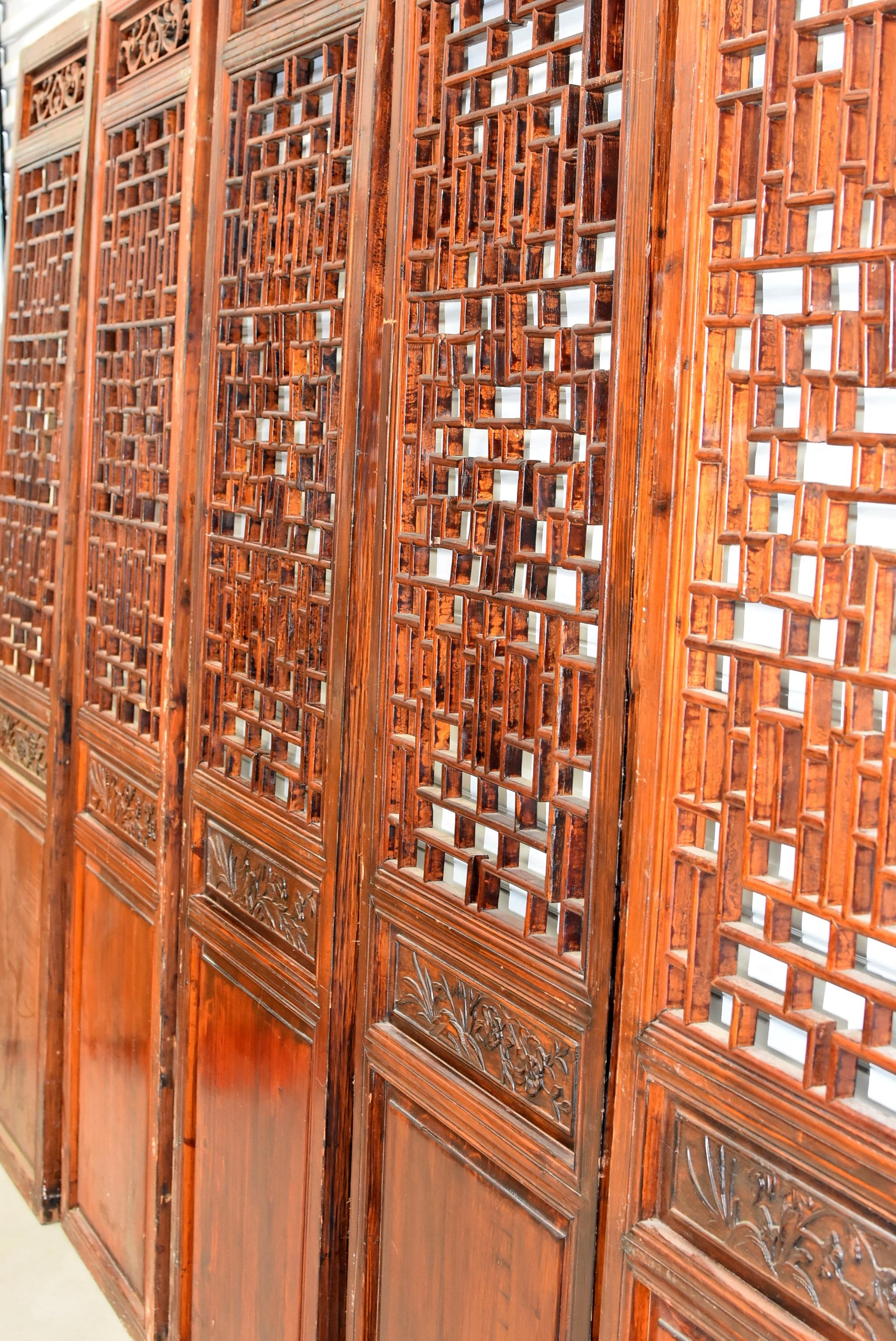A set of beautiful Chinese antique screens in natural finish. Each of the five screens has a middle section featuring a different flower, symbolizing changing of seasons. The main openwork was created using the painstaking joinery method. Every