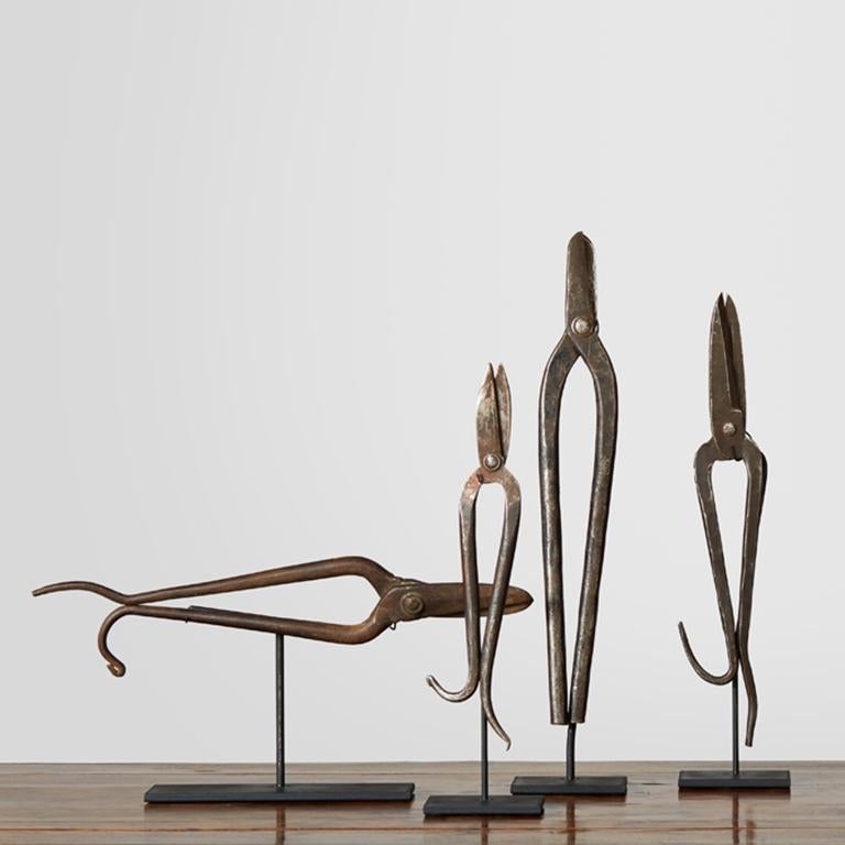 These hand-forged sculptures, with their delicate appearance and whimsical shapes, were once tools integral to a 19th century Chinese shoemaker's trade and fashioned in a way to effectively cut and shape leather. 

Dimensions 
Left to right: