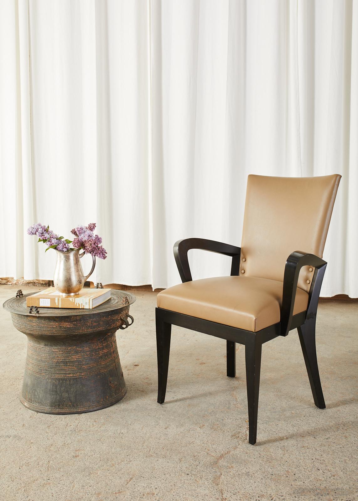 Dramatic set of five leather dining armchairs designed by Dakota Jackson known as Cadette chairs. They feature on an ebonized hardwood frame with gracefully curved arms that flare out like wings and saber style legs. The ergonomic frame has a curved
